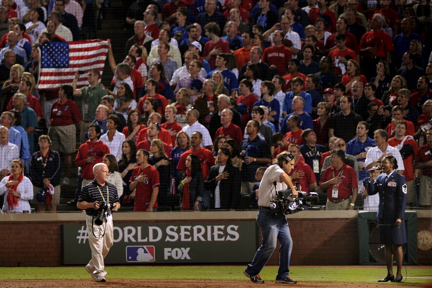 Texas Air National Guard member Master Sgt. Erika Stevens of the 531st Band of the Gulf Coast performs "God Bless America" during the seventh-inning stretch of game four of the Major League Baseball World Series between the St. Louis Cardinals and the Texas, October 23, 2011 at Rangers at Ballpark Stadium in Arlington, Texas. (National Guard photo by Staff Sgt. Eric Wilson).