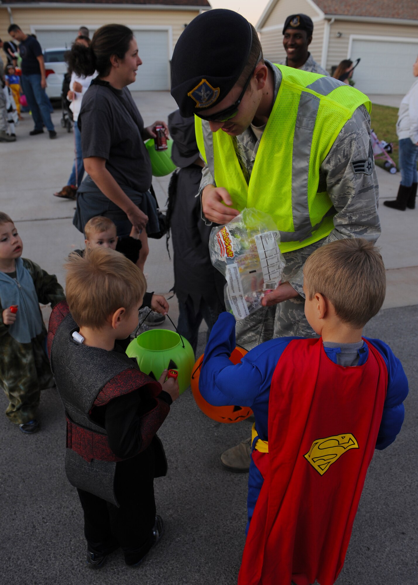 Senior Airman Joshua Stanfield, 7th Security Forces Squadron, hands out candy to trick-or-treaters Oct. 31, 2011, at Dyess Air Force Base, Texas. The 7 SFS monitored the streets in base housing to ensure safety to all participants. (U.S. Air Force photo by Airman 1st Class Jonathan Stefanko/ Released)