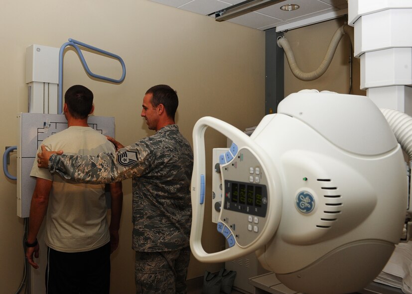 Master Sgt. Keith Pullins, 28th Medical Support Squadron radiology technician, positions Maj. Craig LeQuatte, 28th MDSS diagnostic and therapeutics flight commander, for an x-ray in the medical clinic at Ellsworth Air Force Base, S.D., Oct. 12, 2011. Pullins utilizes the latest radiology equipment to ensure military members are fit to fight. (U.S. Air Force photo by Airman 1st Class Zachary Hada/Released)