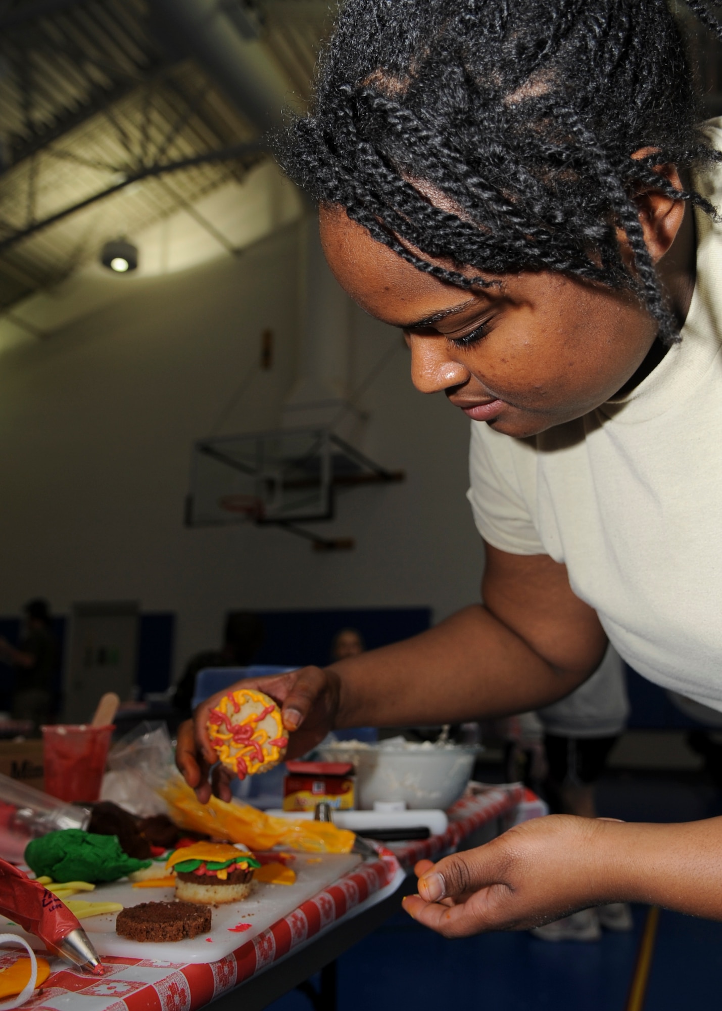 MINOT AIR FORCE BASE, N.D. – Airman 1st Class Natalie Robinson, 'Cop'cake Wars’ 1st place winner and 5th Operations Support Squadron air traffic controller, decorates a cupcake in the form of a hamburger here, Oct 26. October is National Domestic Violence Awareness month and to recognize Minot Air Force Base security forces squadrons, who work to keep our community safe, hundreds of cupcakes were decorated and donated to the four security forces squadrons here. (U.S. Air Force photo/Senior Airman Ashley N. Avecilla)