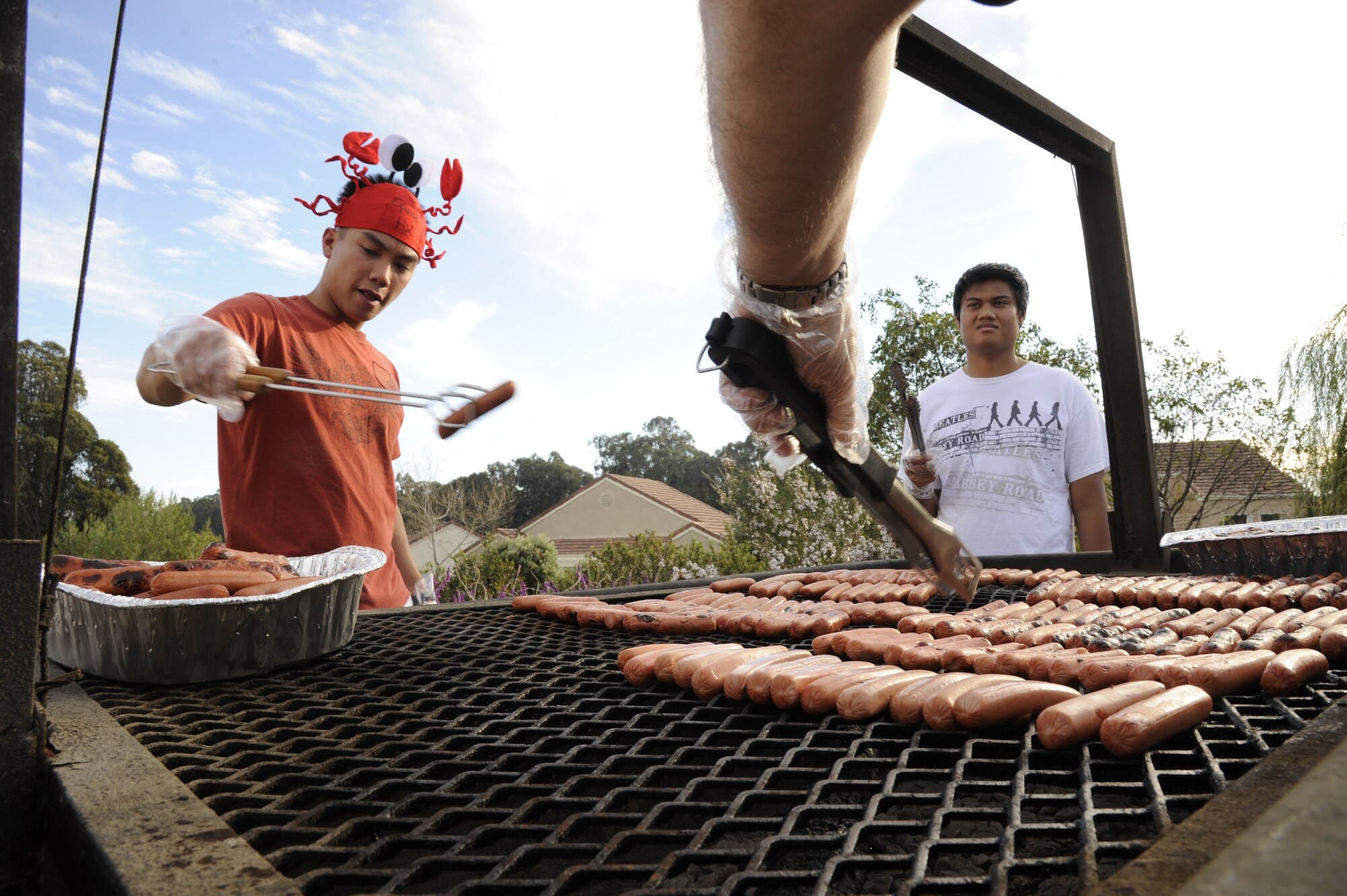 VANDENBERG AIR FORCE BASE, Calif. -- Taking the hot dogs off the grill, 1st Lt. Emmanuel Delacruz, a member of the 4th Space Launch Squadron, helps man a grill during the base's Fall Festival Sunday, Oct. 30, 2011.   The festival was an event for all military personnel and their families hosted by the Vandenberg Chapel Staff to thank servicemembers serving at home and abroad. (U.S. Air Force photo/Senior Airman Lael Huss)