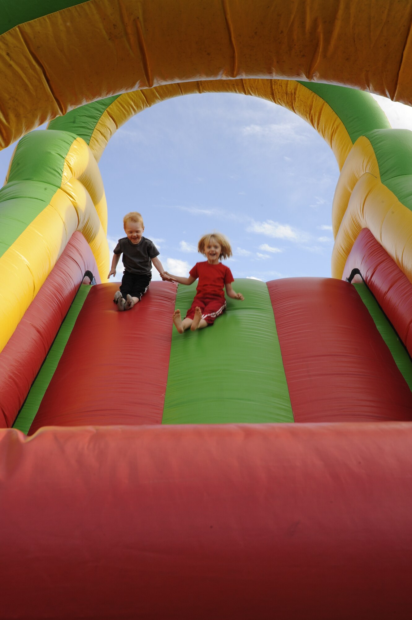VANDENBERG AIR FORCE BASE, Calif. -- George and Evie Eggers slide down a bouncy slide during the base's Fall Festival Sunday, Oct. 30, 2011.  The festival was an event for all military personnel and their families hosted by the Vandenberg Chapel Staff to thank servicemembers serving at home and abroad. (U.S. Air Force photo/Senior Airman Lael Huss) 

 
