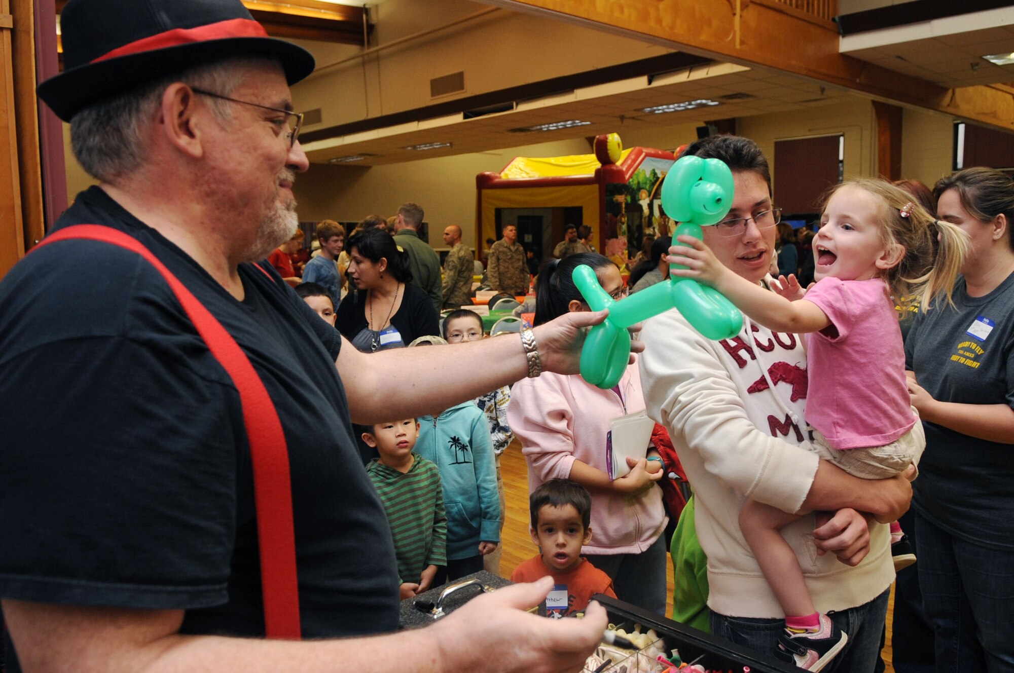 Larry Bean, a magical entertainer, hands Madelynn Byrd, two, a balloon dog Nov. 1, 2011, during the deployed spouses' dinner at Little Rock Air Force Base, Ark. The deployed spouses' dinner provides a home-cooked meal and entertainment for the spouses and families of the deployed Airmen of Little Rock AFB. 