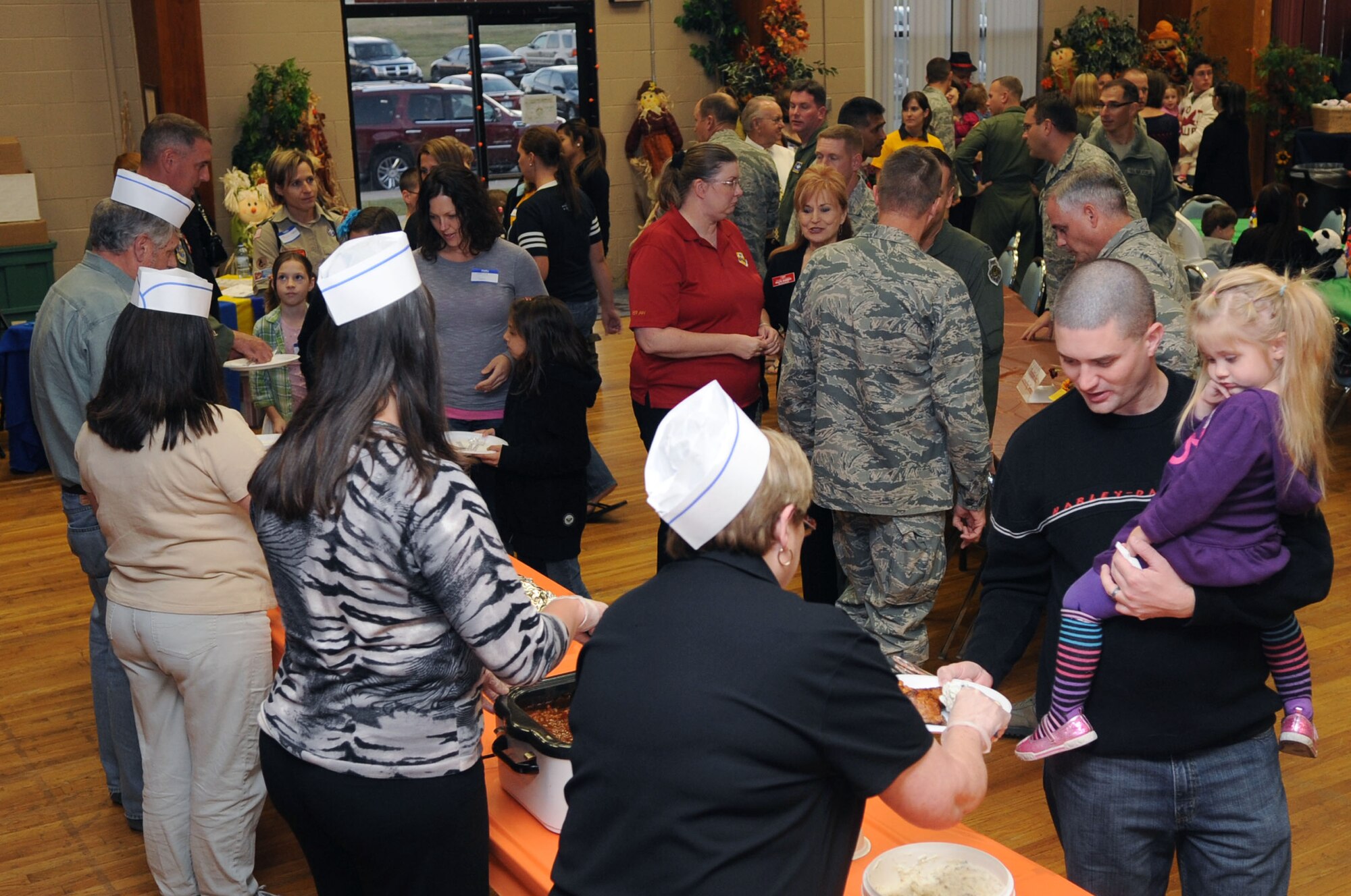 Team Little Rock members serve food to the families of deployed Airmen Nov. 1, 2011, during the deployed spouses' dinner at Little Rock Air Force Base, Ark. The deployed spouses' dinner provides a home-cooked meal for the spouses and family members of deployed Airmen in order to show appreciation for their support to the mission. (U.S. Air Force photo by Staff Sgt. Jim Araos)
