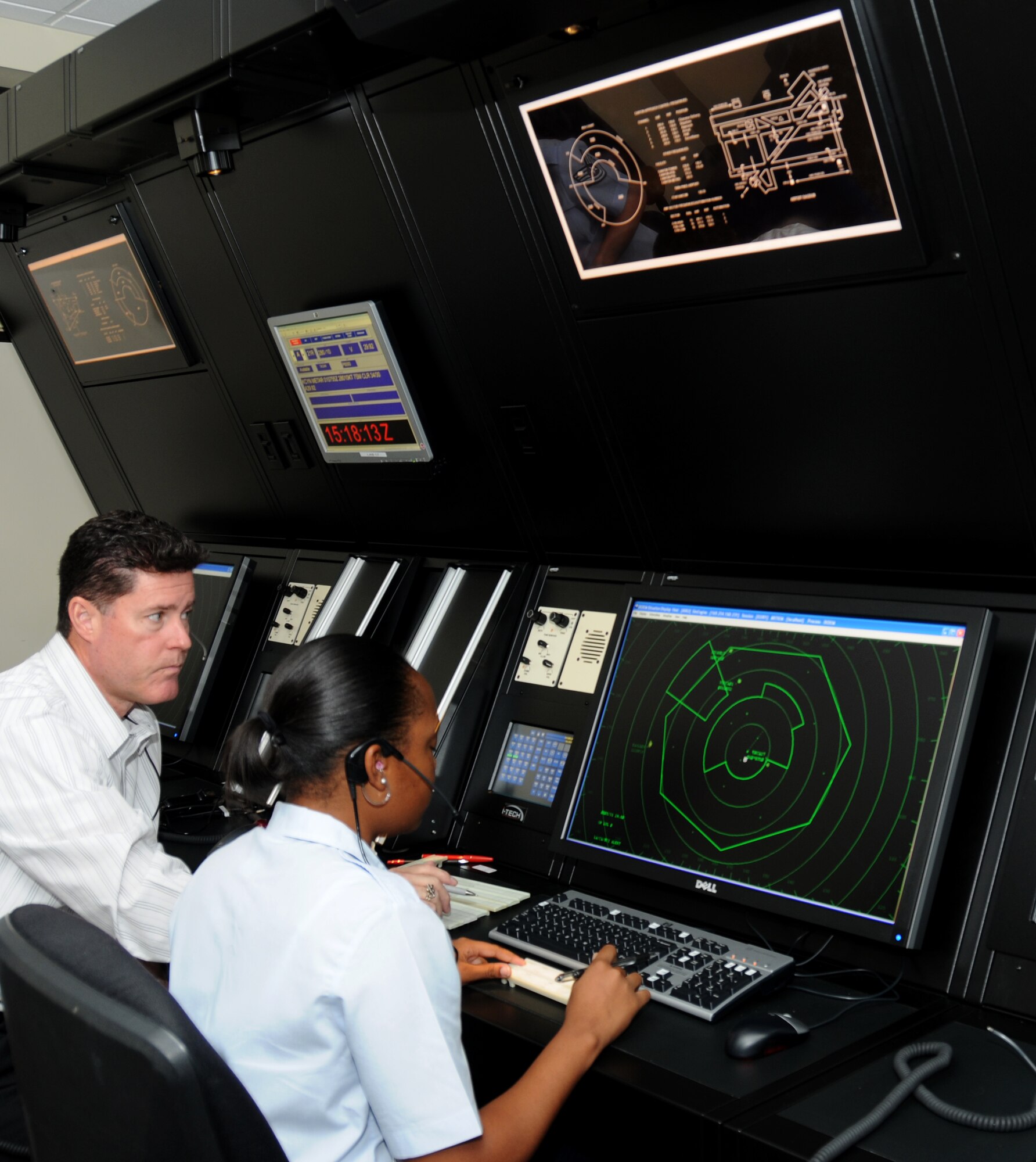 Airman Basic Vaquisha West, 334th Training Squadron, receives assistance from her instructor, Jeffery Cadigan, 334th TRS, with training on the new radar approach control simulator system Oct. 31, 2011, in Cody Hall at Keesler Air Force Base, Miss.  The RAPCON simulator is used for the air traffic control course and has the same look and feel as actual field equipment, using the identical cabinetry.  (U.S. Air Force photo by Kemberly Groue)