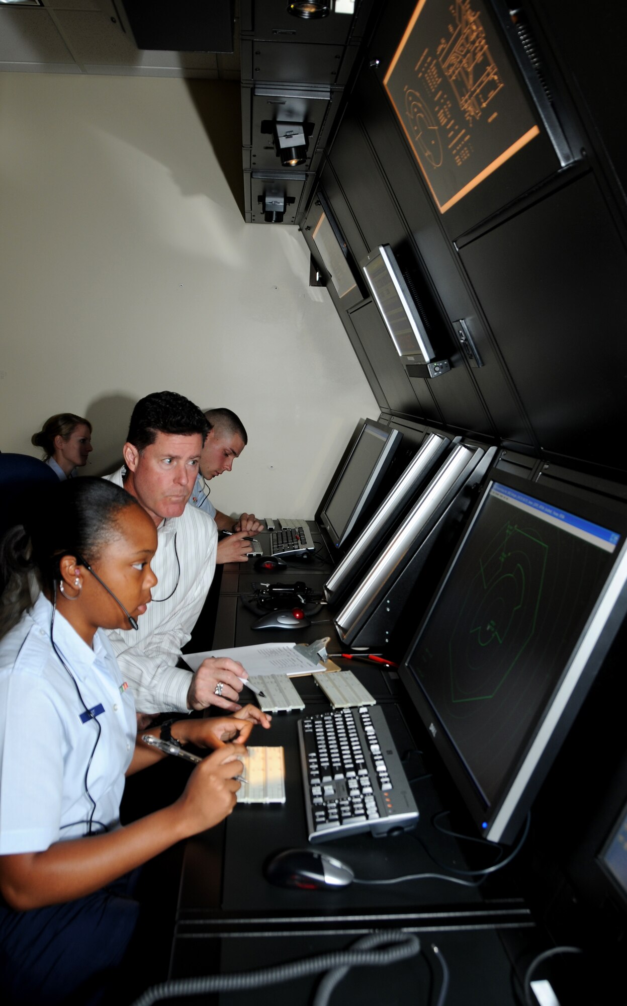 Airman Basic Vaquisha West, 334th Training Squadron, receives assistance from her instructor, Jeffery Cadigan, 334th TRS, with training on the new radar approach control simulator system Oct. 31, 2011, in Cody Hall at Keesler Air Force Base, Miss.  The RAPCON simulator is used for the air traffic control course and has the same look and feel as actual field equipment, using the identical cabinetry.  (U.S. Air Force photo by Kemberly Groue)