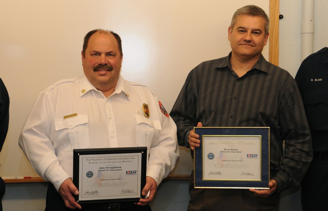 John Strongitharm and Bryan Bushey from the Duluth, Minn. Fire department are seen holding the Patriot award during a ceremony held at the Duluth Fire department.  The Patriot award was given to recognize these supervisors for their support of Guard and Reserve members.  (National Guard photo by Master Sgt. Ralph Kapustka/released)