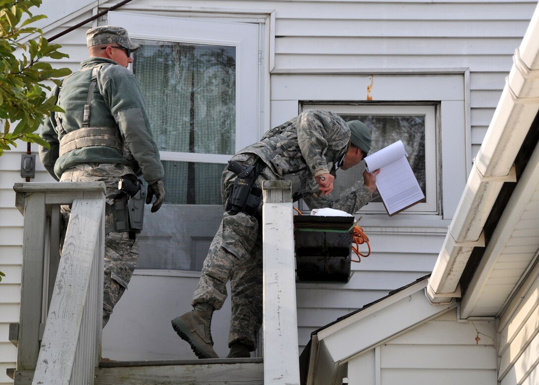 Senior Airman Steven Vignault and Technical Sgt. Stephen Jeffers, 104th Fighter Wing Security Forces members, perform door-to-door wellness checks in Sunderland Massachusetts. on Oct 31, 2011. (photograph by Maj. Matthew T. Mutti, 104FW/CCE)