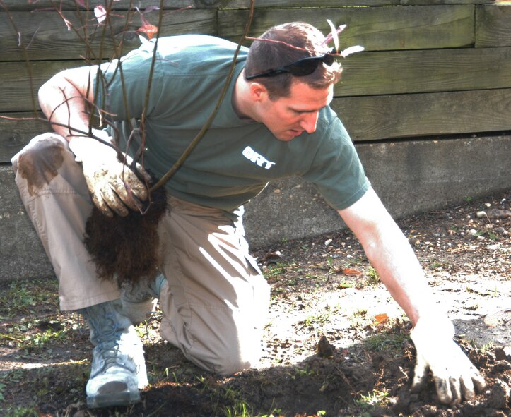An Air Force Office of Special Investigations member plants a tree in front of one of the Action In Community Through Service buildings. Several OSI members took time off to give back to their community by sprucing up the grounds around one of the ACTS facilities Oct 31. ACTS is a community service agency that works in the northern Virginia area to alleviate hunger, homelessness and domestic violence, and to help people achieve self-sufficiency. (U.S. Air Force Photo by Mr. James C. Dillard)