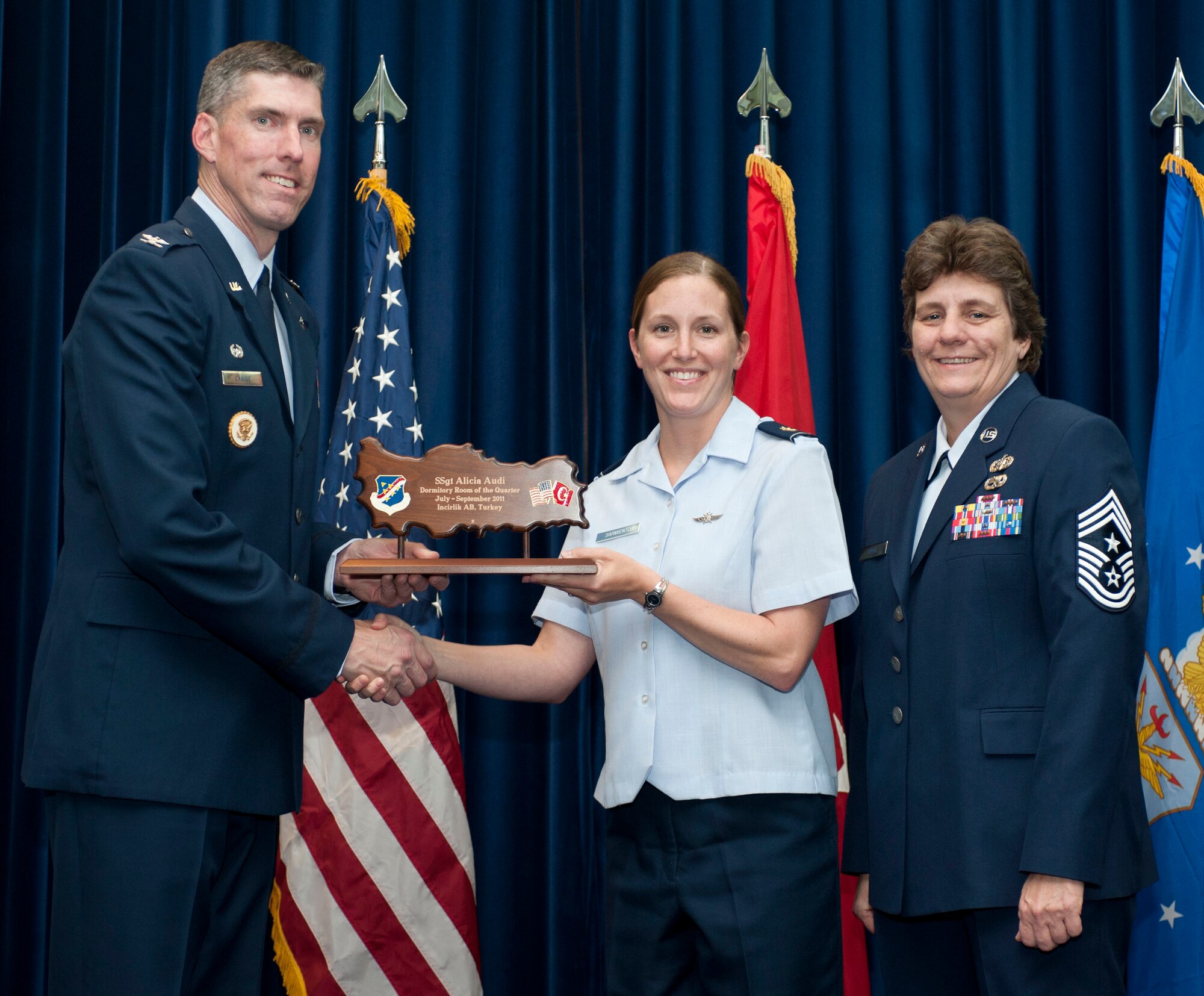 Maj. Traci Sarmiento, 39th Communications Squadron, accepts the Dormitory Room of the Quarter Award on behalf of Staff Sgt. Alicia Audi, 39th CS, Oct. 31, 2011, in the Club Complex ballroom at Incirlik Air Base, Turkey.(U.S. Air Force photo by Senior Airman Clayton Lenhardt/Released)