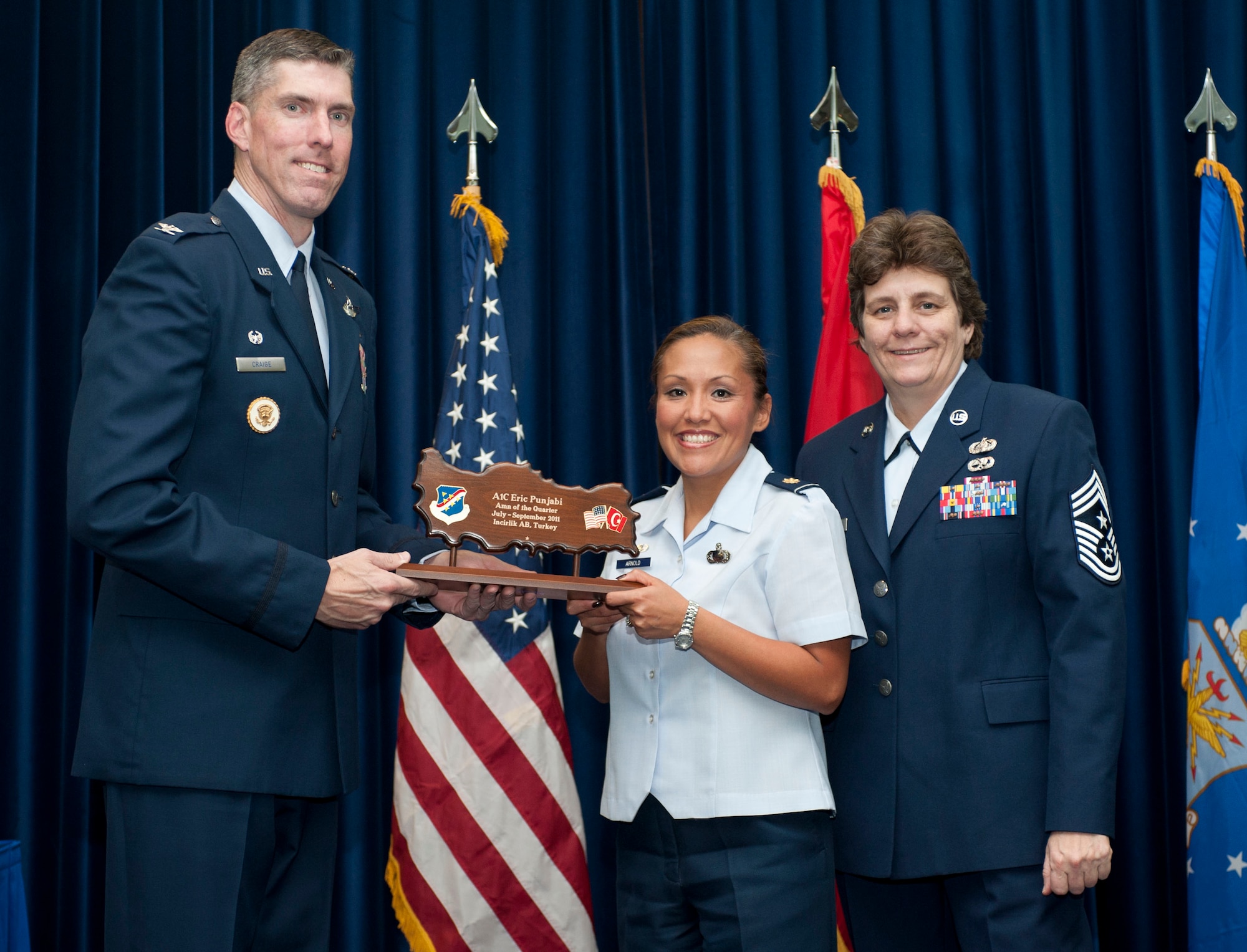 Maj. Kim Arnold, 39th Contracting Squadron commander, accepts the wing-level Airman of the Quarter Award on behalf of Airman 1st Class Eric Punjabi, 39 CONS, Oct. 31, 2011, in the Club Complex ballroom at Incirlik Air Base, Turkey.(U.S. Air Force photo by Senior Airman Clayton Lenhardt/Released)