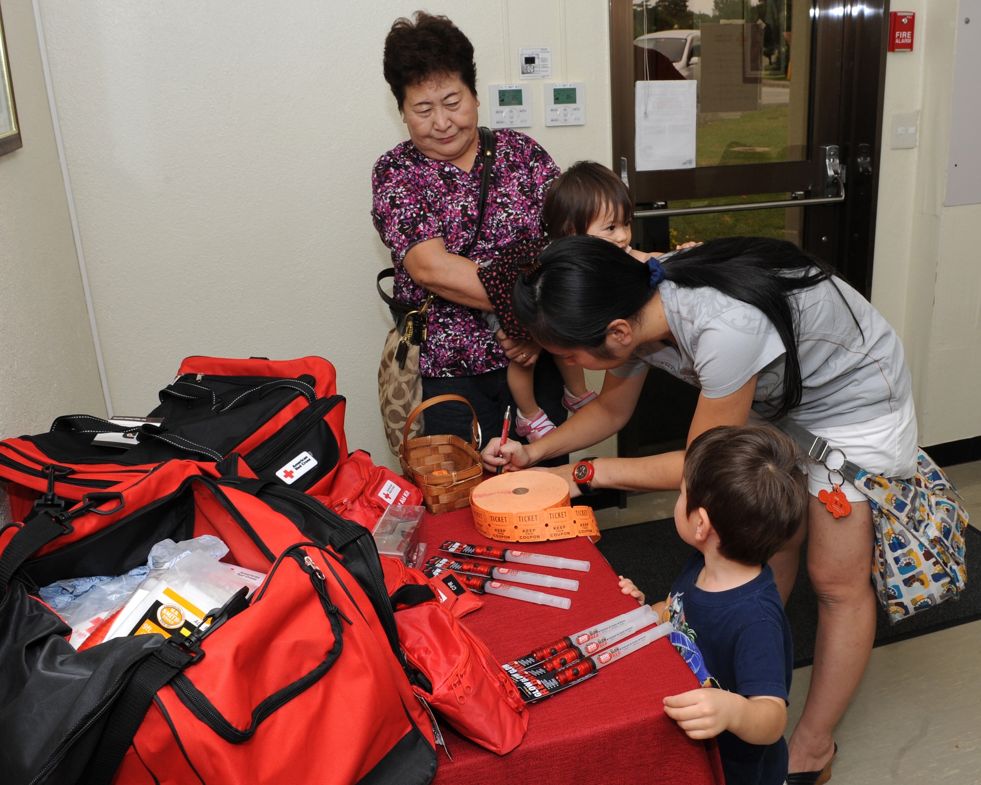 Participants at the Kadena Red Cross open house enter their names for door prizes during the event on Kadena Air Base, Japan, Oct. 31. During the event, participants at the event received a grand tour of the new facility as well as face painting, refreshments and door prizes. (U.S. Air Force photo/Junko Kinjo/released)