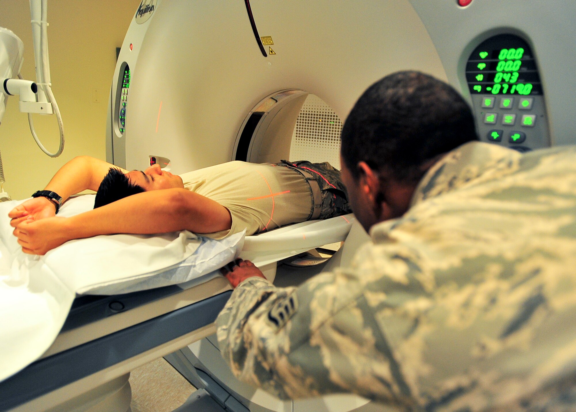 Staff Sgt. Kevin Collymore, 51st Medical Operations Squadron radiology technician, checks to see if a patient is level before beginning the Computerized Axial Tomographic scan Nov. 1, 2011. The CAT scan is a type of X-ray that is utilized to diagnose abnormities in trauma patients. (U.S. Air Force photo/Senior Airman Adam Grant)