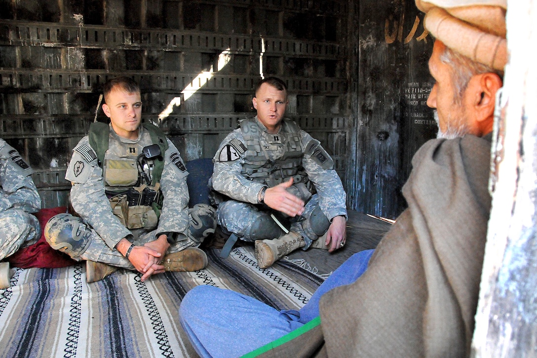 Army Capt.'s Tyler Vest, left, and Robert Gacke, right, meet with the ...