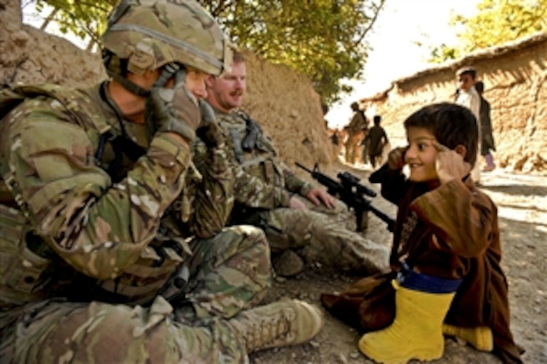U.S. Air Force Capt. (Dr.) Michael Madsen plays with an Afghan child during a visit to his village in Zabul province, Afghanistan, Oct. 26, 2011. Madsen is the senior medical officer assigned to Provincial Reconstruction Team Zabul. 