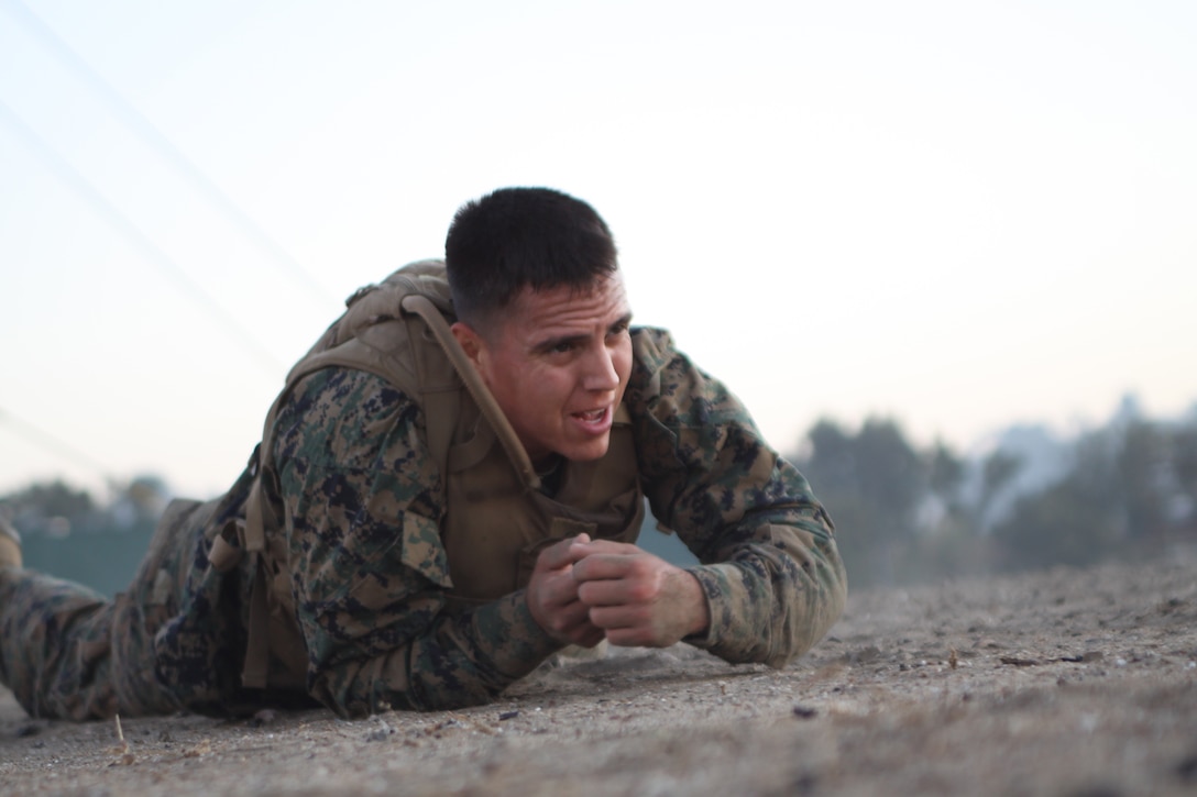 Cpl. Oscar Roman, civil affairs noncommissioned officer, 3rd Civil Affairs Group, Marine Corps Base Camp Pendleton, low crawls during the first field exercise of the Martial Arts Instructor Course aboard Marine Corps Recruit Depot San Diego Nov. 2. There is one instructor for every 12 students to ensure they receive the attention they need to be successful and remain safe throughout the course.