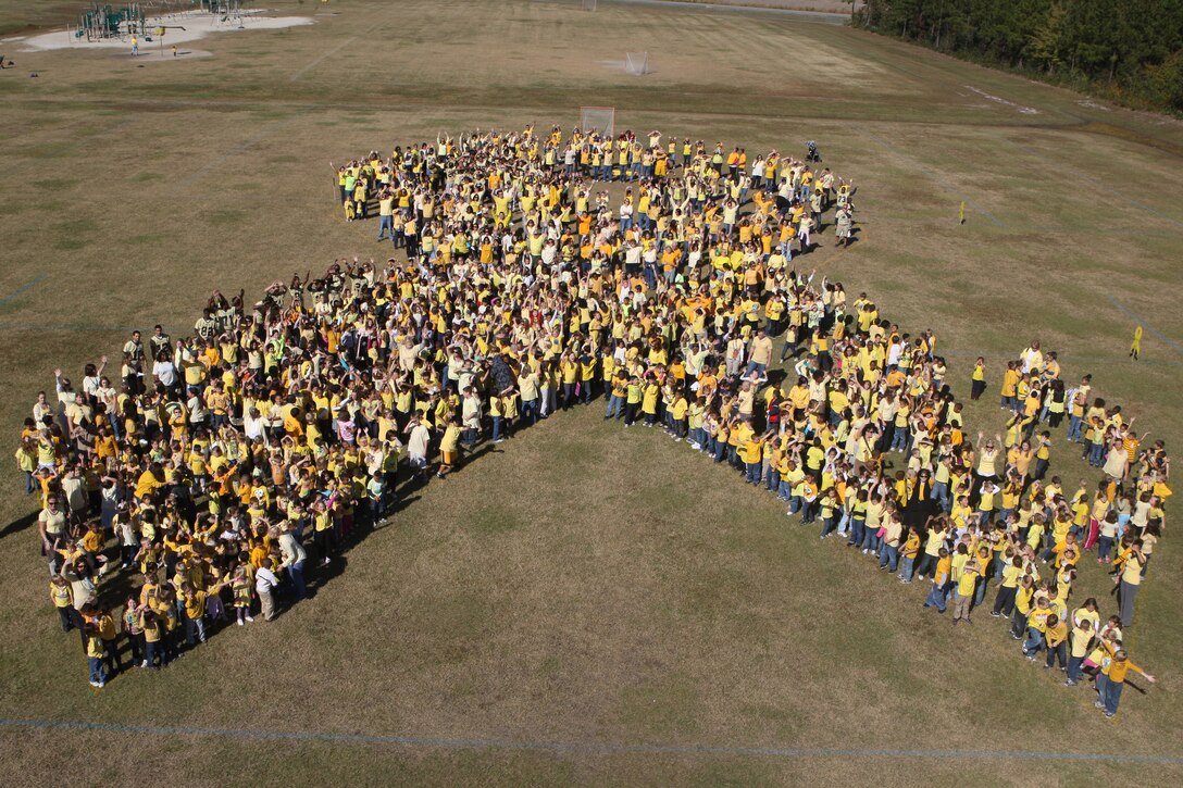 Children, civilian and service members stand together at the Carolina Forest Elementary School soccer field in an attempt to break the Guinness world record of the largest human yellow ribbon, Nov. 3. In support of November’s Month of the Military Family, children from elementary schools to high schools throughout Jacksonville, N.C. as well as civilian and service members came together to recognize the sacrifices of those involved in serving the country.