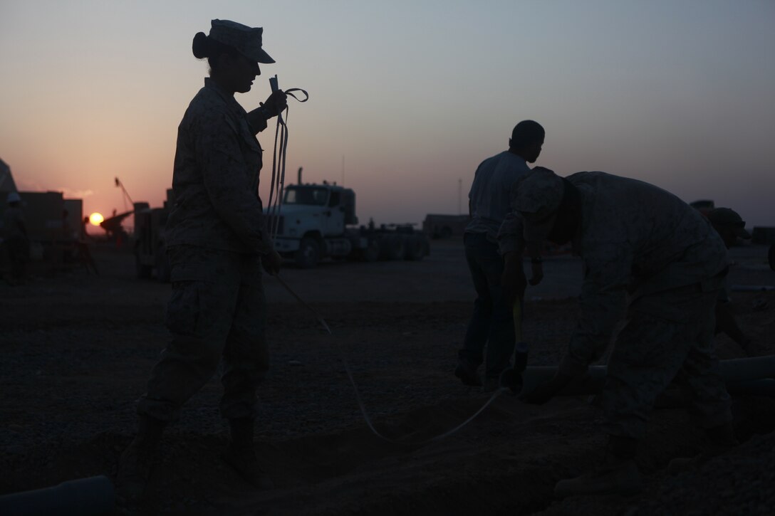Cpl. Kayla Erianne, a field radio operator, helps her Marines pull tape through conduit being placed underground for fiber optic cable at Camp Dwyer, Afghanistan Nov. 3. Erianne, from Bridgeton, N.J., helped to lead the Marines of Marine Wing Communications Squadron 28 to complete a fiber optic upgrade at Camp Dwyer. The upgrade will bring more durable and reliable communications to the units in southwestern Afghanistan.
