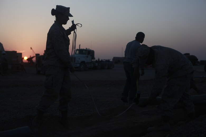 Cpl. Kayla Erianne, a field radio operator, helps her Marines pull tape through conduit being placed underground for fiber optic cable at Camp Dwyer, Afghanistan Nov. 3. Erianne, from Bridgeton, N.J., helped to lead the Marines of Marine Wing Communications Squadron 28 to complete a fiber optic upgrade at Camp Dwyer. The upgrade will bring more durable and reliable communications to the units in southwestern Afghanistan.