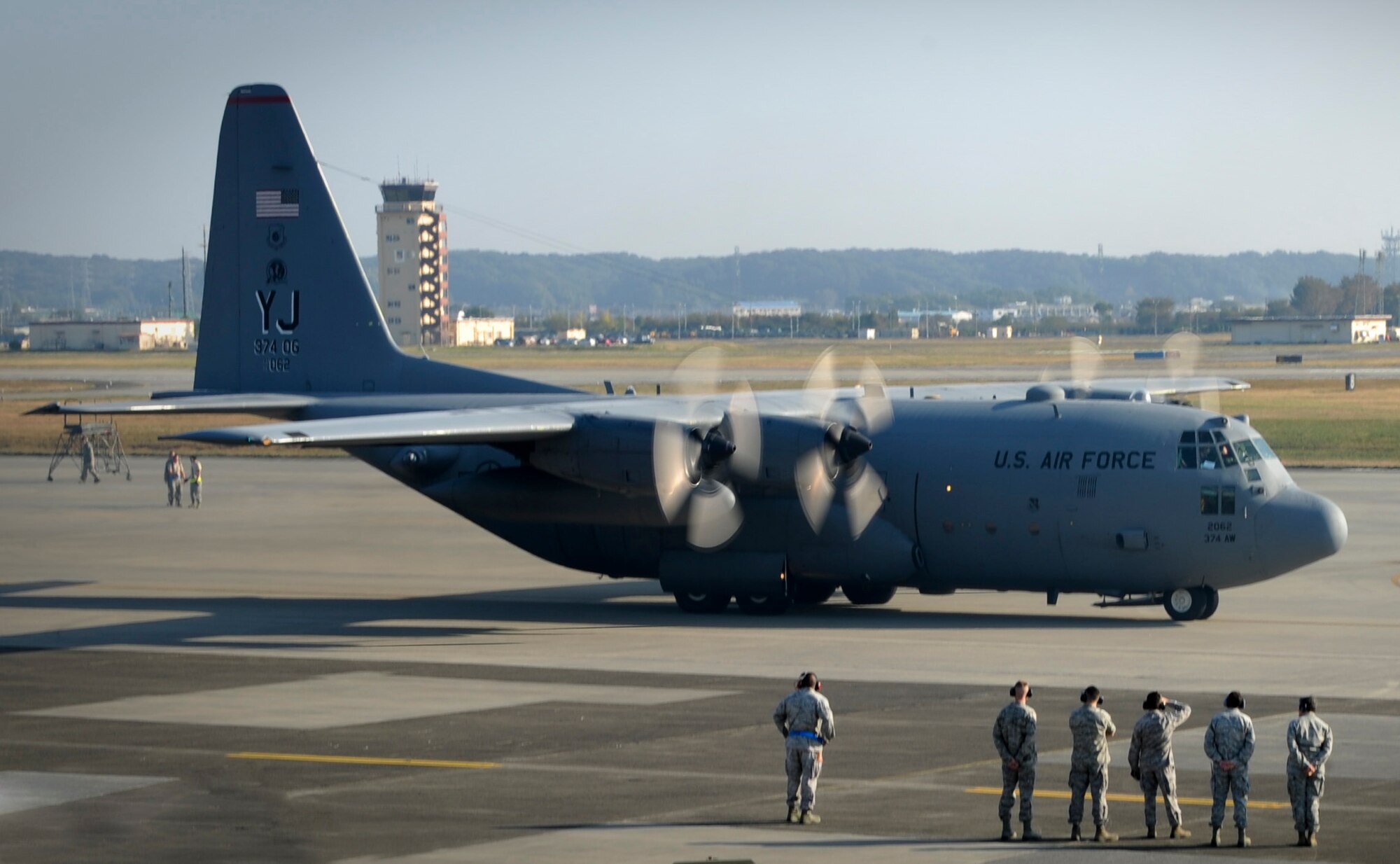 YOKOTA AIR BASE, Japan -- A C-130 Hercules taxis past aircraft maintainers prior to take-off, during a Samurai Surge exercise, Yokota Air Base, Japan, Nov. 2, 2011. Aircrew from the 36th Airlift Squadron participated in Samurai Surge, an all-day training exercise testing mission capability of many agencies throughout the base. (U.S. Air Force photo/Staff Sgt. Stacy Moless)
