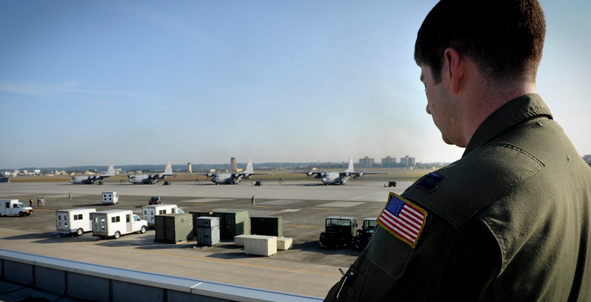 YOKOTA AIR BASE, Japan -- Captain Jeremy Bower, 36th Airlift Squadron watches as six C-130 Hercules simultaneously start their engines and prepare to fly in formation and demonstrated their airdrop and large formation capabilities,Yokota Air Base, Japan Nov. 2, 2011. Aircrew from the 36th Airlift Squadron participated in Samurai Surge, an all-day training exercise testing mission capability of many agencies throughout the base. (U.S. Air Force photo/Staff Sgt. Stacy Moless)