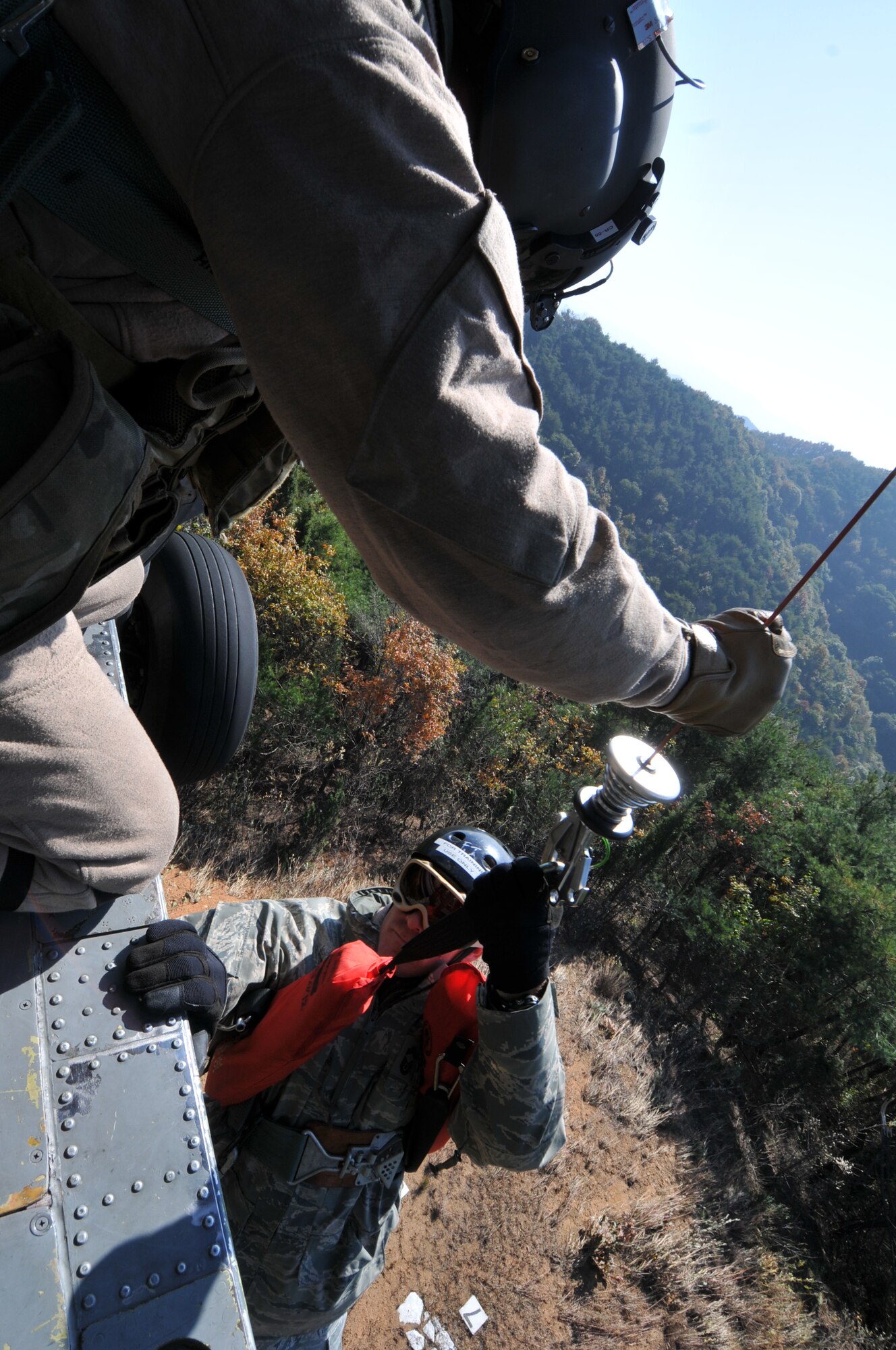 U.S. Air Force Chief Master Sgt. Jeremy Ravlin, 33rd Helicopter Maintenance Unit, is hoisted up from the helicopter with the assistance of U.S. Air Force Staff Sgt. Brandon Taylor, 33rd Rescue Squadron HH-60G Flight Engineer, both from Kadena Air Base, Japan, during exercise PACIFIC THUNDER Nov. 1, 2011 near Osan Air Base, Korea.


PACIFIC THUNDER is a 10-day exercise, from Oct. 31-Nov. 09, at Osan AB, Korea involving the 33rd Rescue Squadron, Kadena AB, Japan, and the 25th Fighter Squadron, Osan AB, Korea. These units work together to practice Combat Search and Rescue tactics to prepare for real-world emergency situations. 
(U.S. Air Force photo/Tech. Sgt. Angelique Bilog/released)
