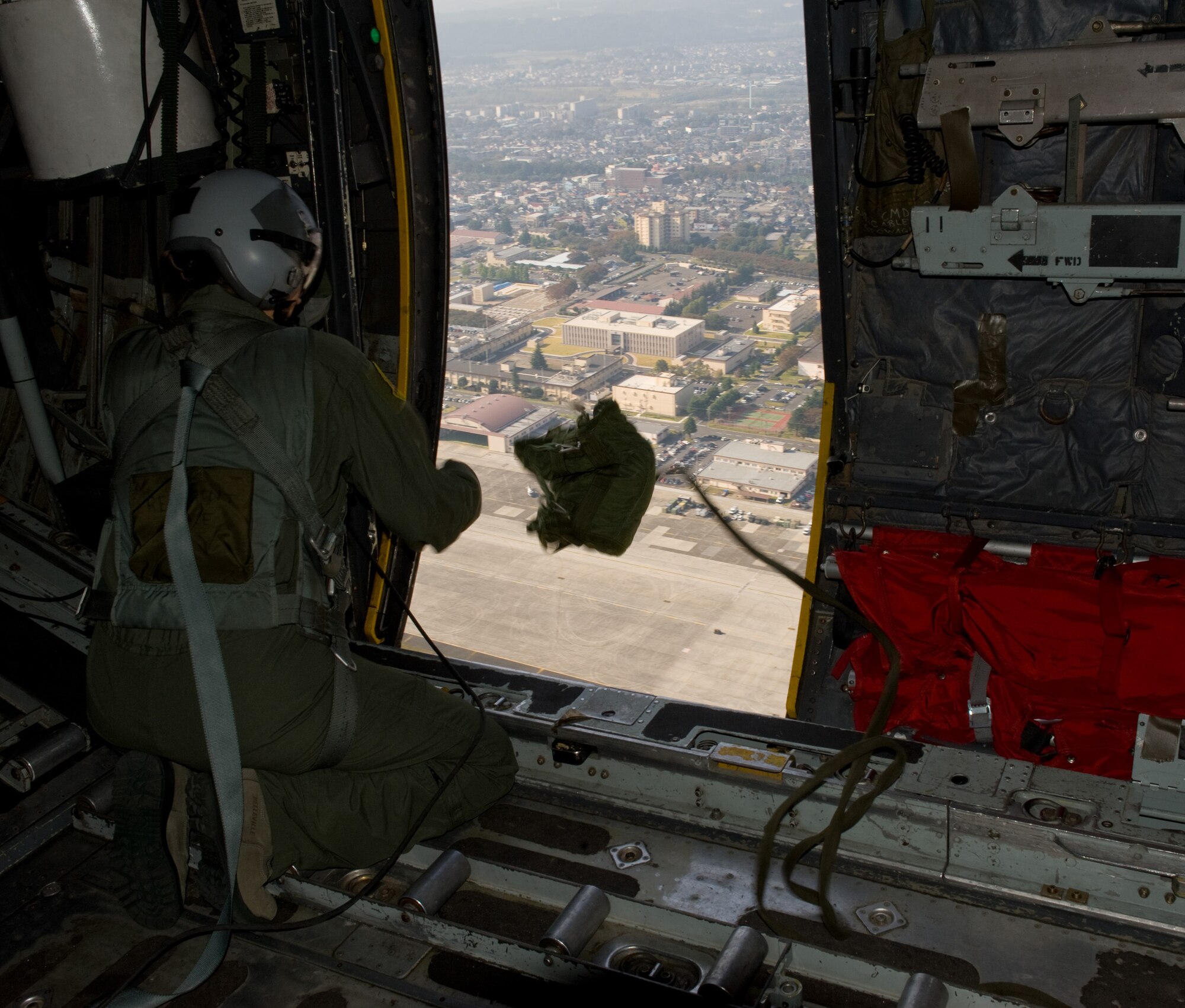 YOKOTA AIR BASE, Japan -- Senior Airman Chelsea Priebe, 36th Airlift Squadron loadmaster, drops a simulated light load pack out of a C-130 Hercules at Yokota Air Base, Japan, Nov. 2, 2011. Yokota's C-130 crews tested multiple airdrop proficiencies during a Samurai Surge. (U.S. Air Force photo/Airman 1st Class Krystal M. Garrett) 