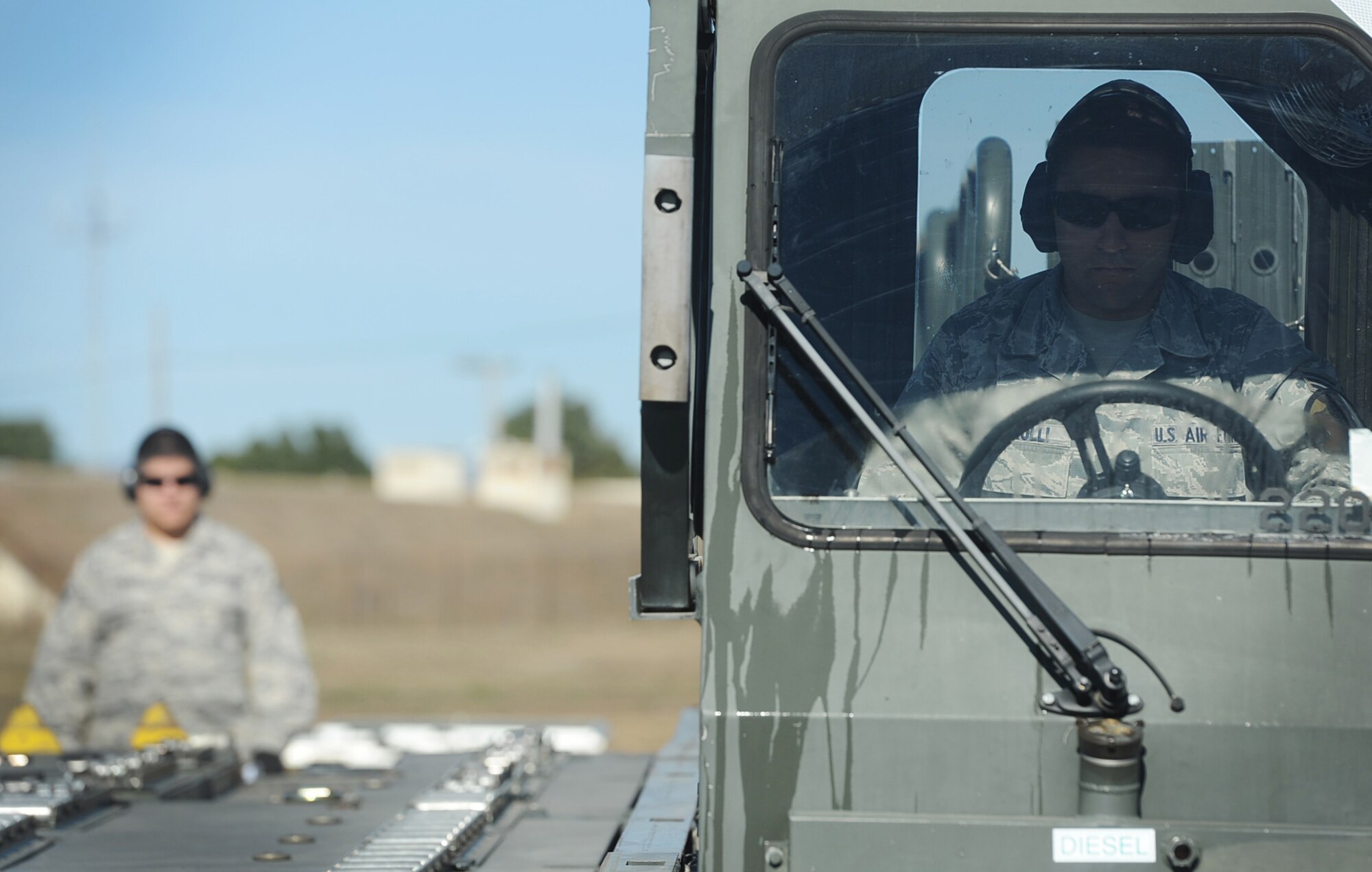 Staff Sgt. Luis Avila, 571st GMS, looks on as Senior Airman Joshua Ferrulli, 571st GMS, operates the Next Generation Small Loader during the 60th Air Mobility Wing conducted staff assistance visit for the upcoming Logistics Compliance Assessment Program. (U.S. Air Force Photo/ Master Sgt. Stan Parker)