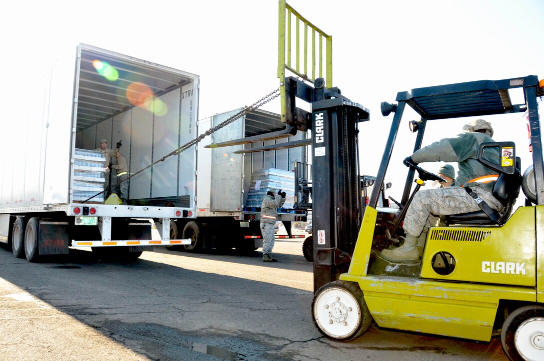 Master Sgt. Fenton Lewis from the 103rd Logistics Readiness Squadron pulls a pallet of water closer to the trailer’s edge as Senior Master Sgt. D. Matthew Liddell, superintendent, 103rd Logistics Readiness Squadron, gives the commands from inside the trailer at Rentschler Field in East Hartford, Conn. Nov. 1, 2011. Both the Airmen are part of the Connecticut National Guard’s commodities distribution center that is staging water and meals-ready-to-eat for delivery to Connecticut towns in need in the wake of the massive destruction caused by an autumn snowstorm. (U.S. Air Force photo by Tech. Sgt. Joshua Mead)