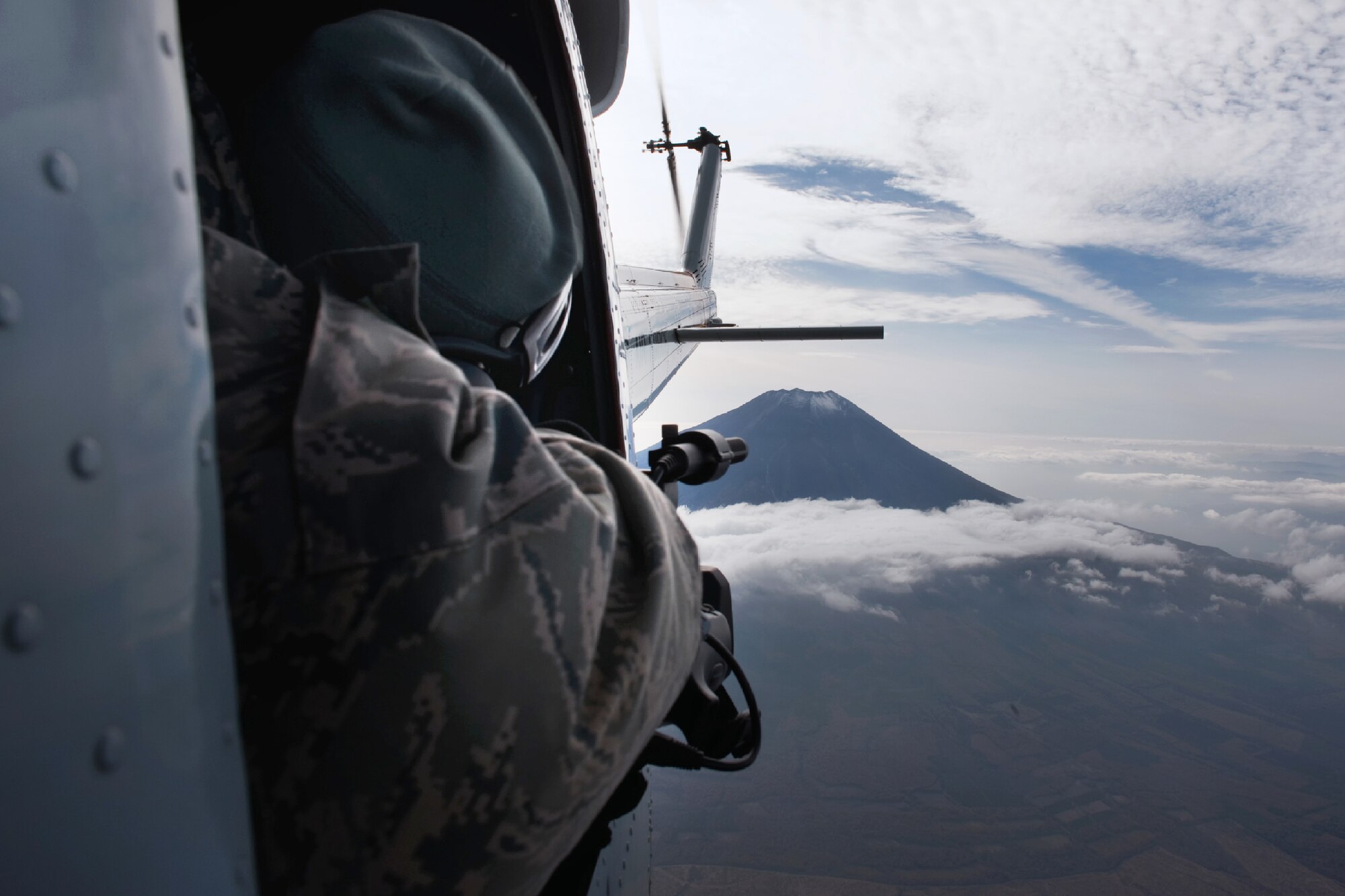 OVER MOUNT FUJI, Japan -- Tech. Sgt. Juaacklyn Denny, 374th Airlift Wing broadcaster, captures video from UH-1 Huey, Nov. 2, 2011 during the Samurai Surge. The Samurai Surge an all day flying exercise tested pilots from the 459th AS and 36th AS in several different areas. (U.S. Air Force photo/Osakabe Yasuo)