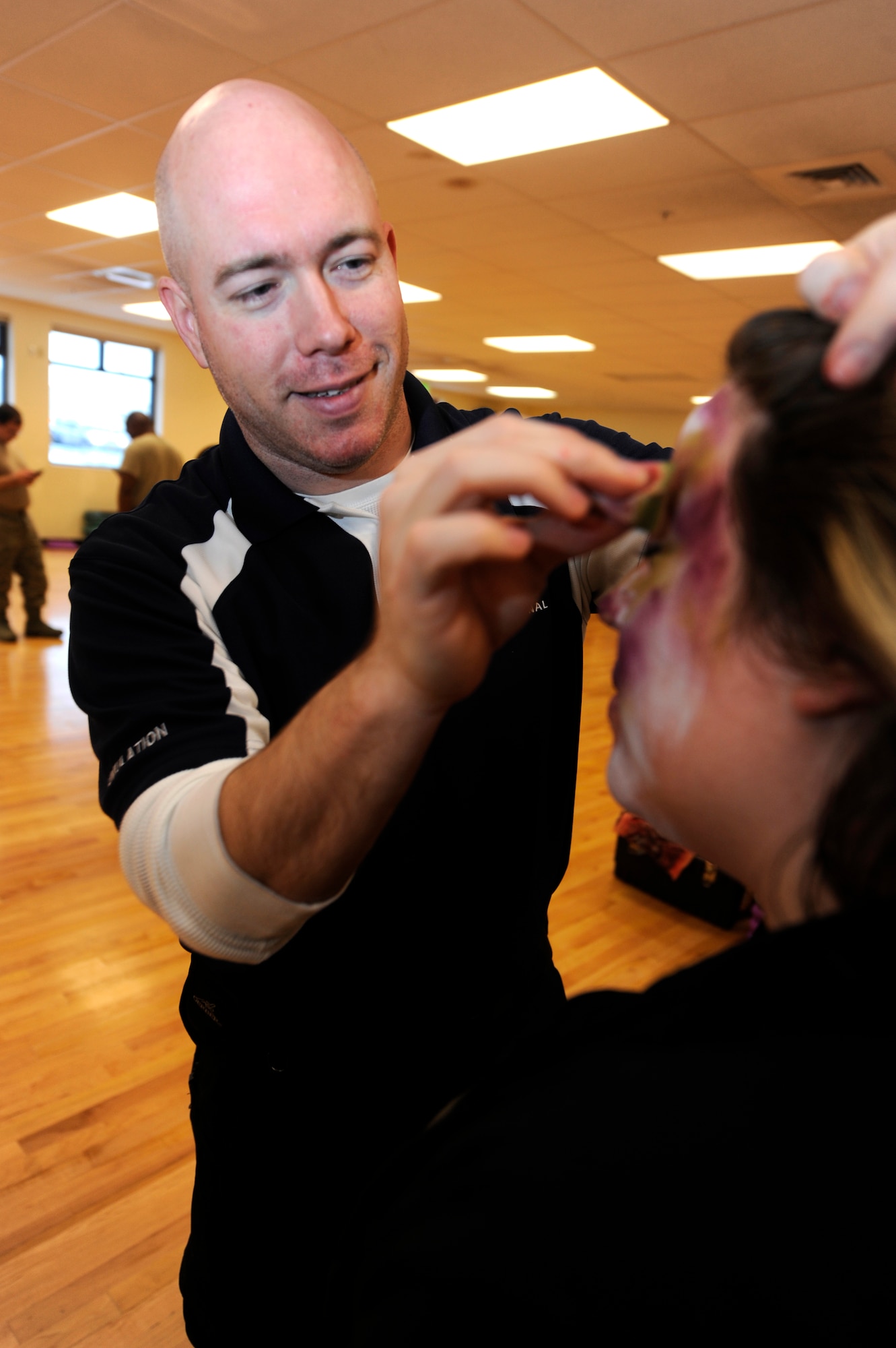 Will Enfinger, left, creates a facial discoloration for Kendra Goodman in preparation for a simulated zombie invasion in the Joint Base Elmendorf-Richardson Fitness Center Oct. 31, 2011. Zombies were chosen in the spirit of the Halloween season and used to help the moulage team practice their skills. Enfinger is a simulation operator for the hosptiral?s Simulation Center, which specializes in creating realistic wounds and scenarios. Goodman is the wife of Master Sgt. Brian Goodman, 3rd Aircraft Maintenance Support Squadron superintendant. (U.S. Air Force photo/Staff Sgt. Robert Barnett/Released)