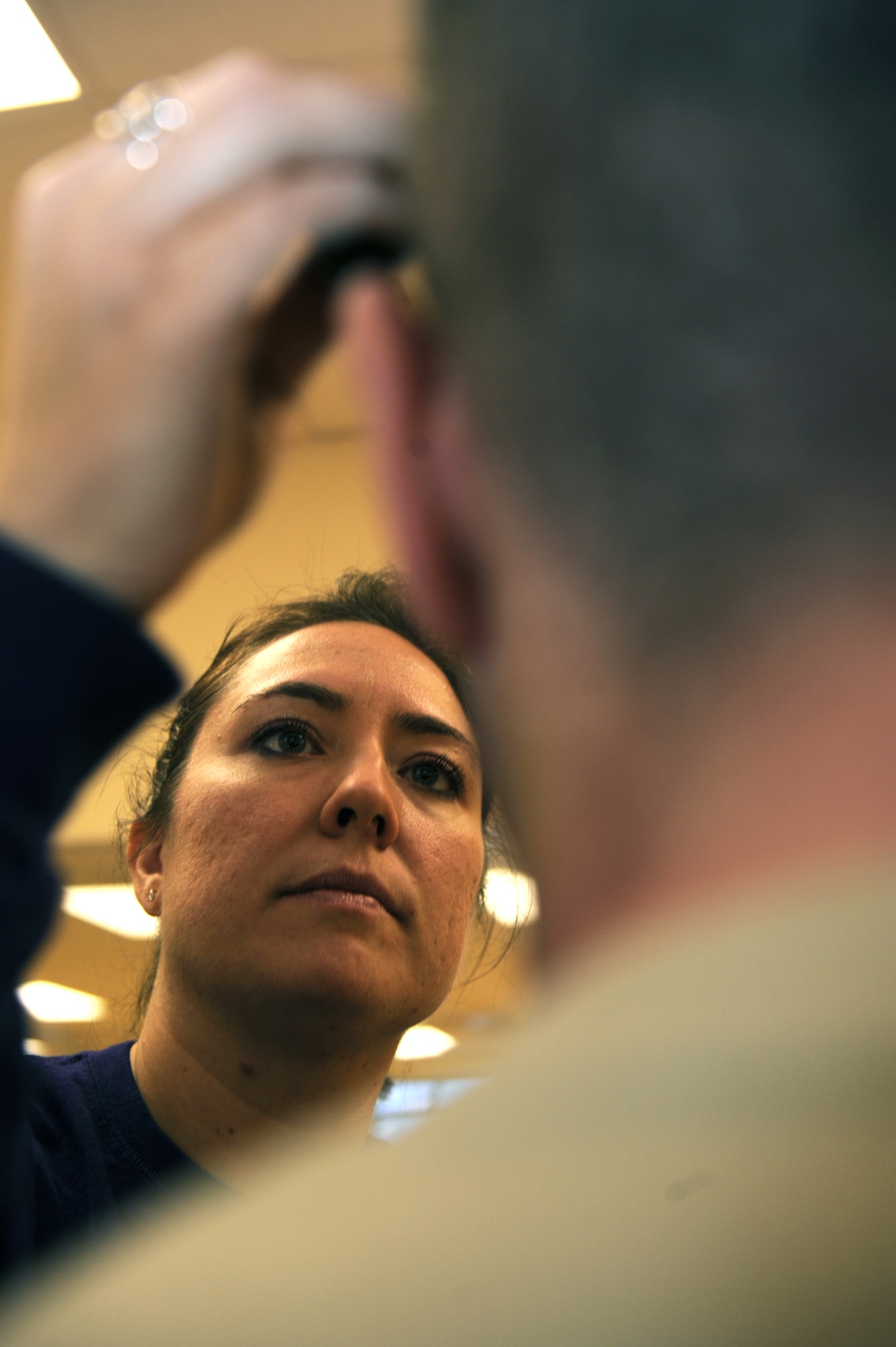 Master Sgt. Michelle Long paints Master Sgt. Brian Goodman's face in preparation for a simulated zombie invasion in the Joint Base Elmendorf-Richardson Fitness Center Oct. 31, 2011. Zombies were chosen in the spirit of the Halloween season and used to help the moulage team practice their skills. Long is the noncommissioned officer-in-charge of Dental Records and Reception at the hospital and volunteered to work with the moulage team for the hospital?s Simulation Center, which specializes in creating realistic wounds and scenarios. Goodman is a 3rd Aircraft Maintenance support section superintendent. (U.S. Air Force photo/Staff Sgt. Robert Barnett/Released)