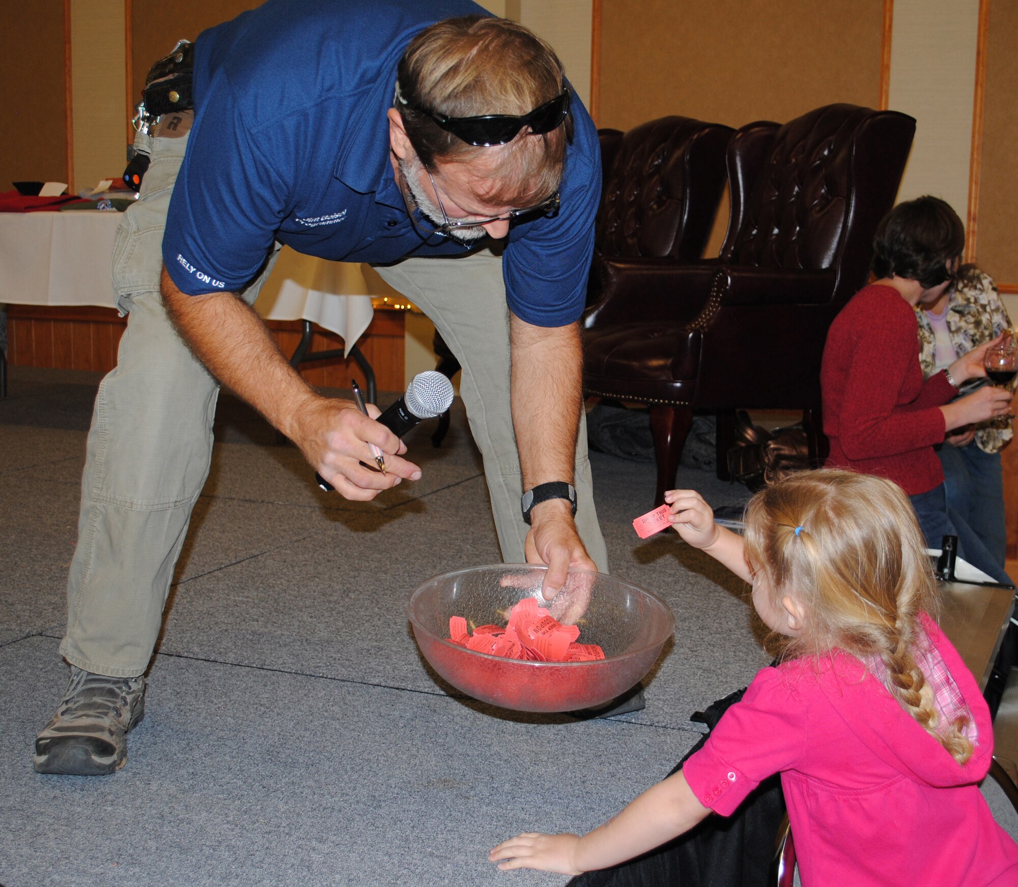Jim Beisel, 341st Force Support Squadron Outdoor Recreation programmer, holds a bowl of raffle tickets for Rebecca Kofoed, 5, to draw a winner. Various types of wine and ski prizes were given away during the event that featured many vendors offering helpful tips and competitive rates for those attending. (U.S. Air Force photo/Airman Cortney Paxton)
