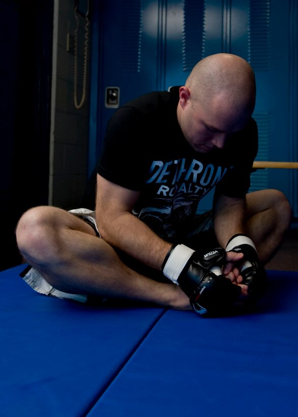 Once his hands were wrapped, Turner stretched to prepare his body to fight. (U.S. Air Force photo by Airman 1st Class Kate Thornton/Released)