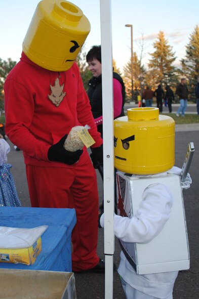Father and son dress up as Lego people for Halloween and take in the fun in front of the commanders' houses. (U.S. Air Force photo/Airman 1st Class Katrina Heikkinen)