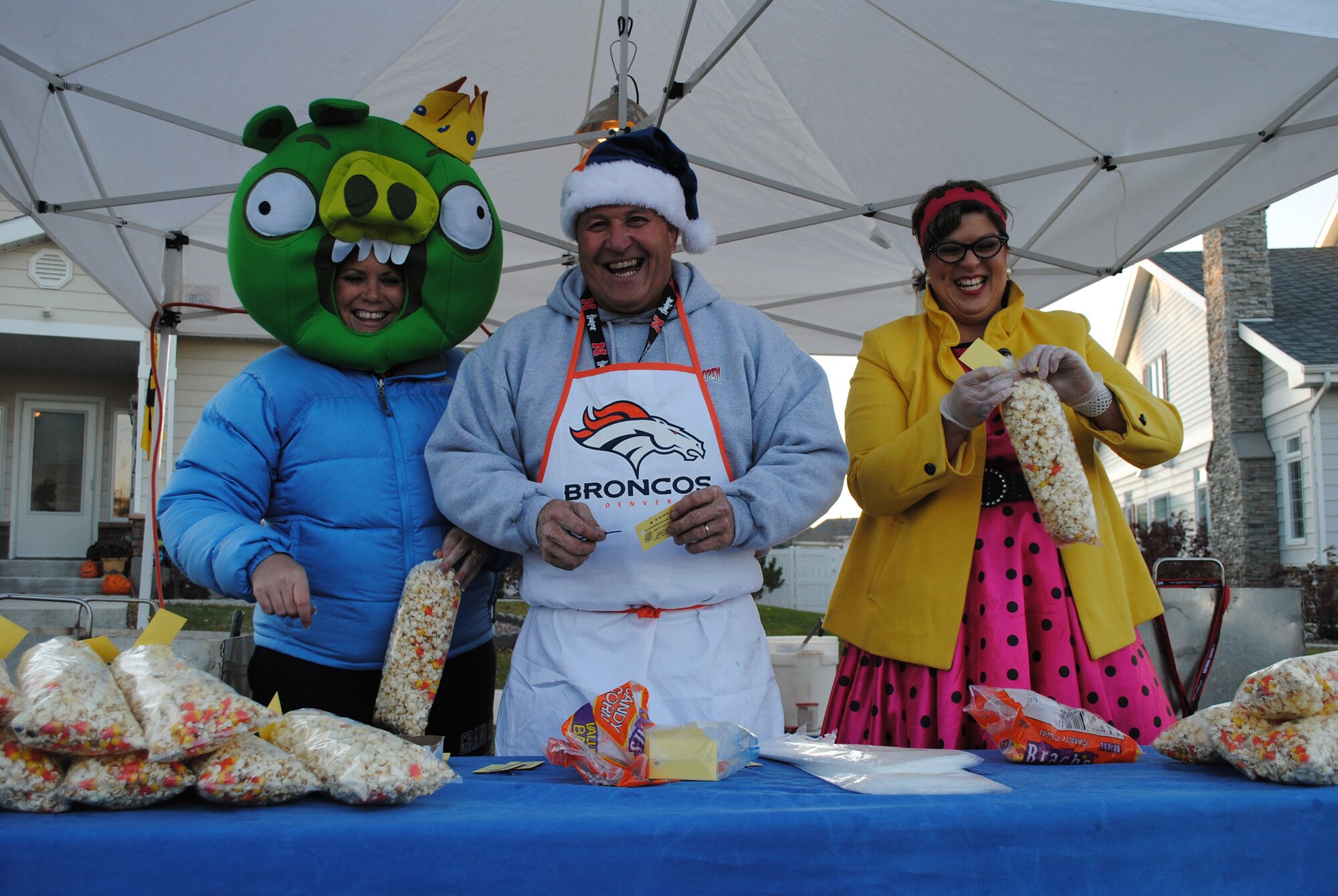 Left to right, Misty and Donald Jenkins, along with Kari Johnson, from a local popcorn business, donated the supplies and volunteered to make organic, sweet and salty popcorn to be distributed to trick-or-treaters Oct. 29 outside the homes of the 341st Missile Wing commander and vice commander. (U.S. Air Force photo/Airman 1st Class Katrina Heikkinen)