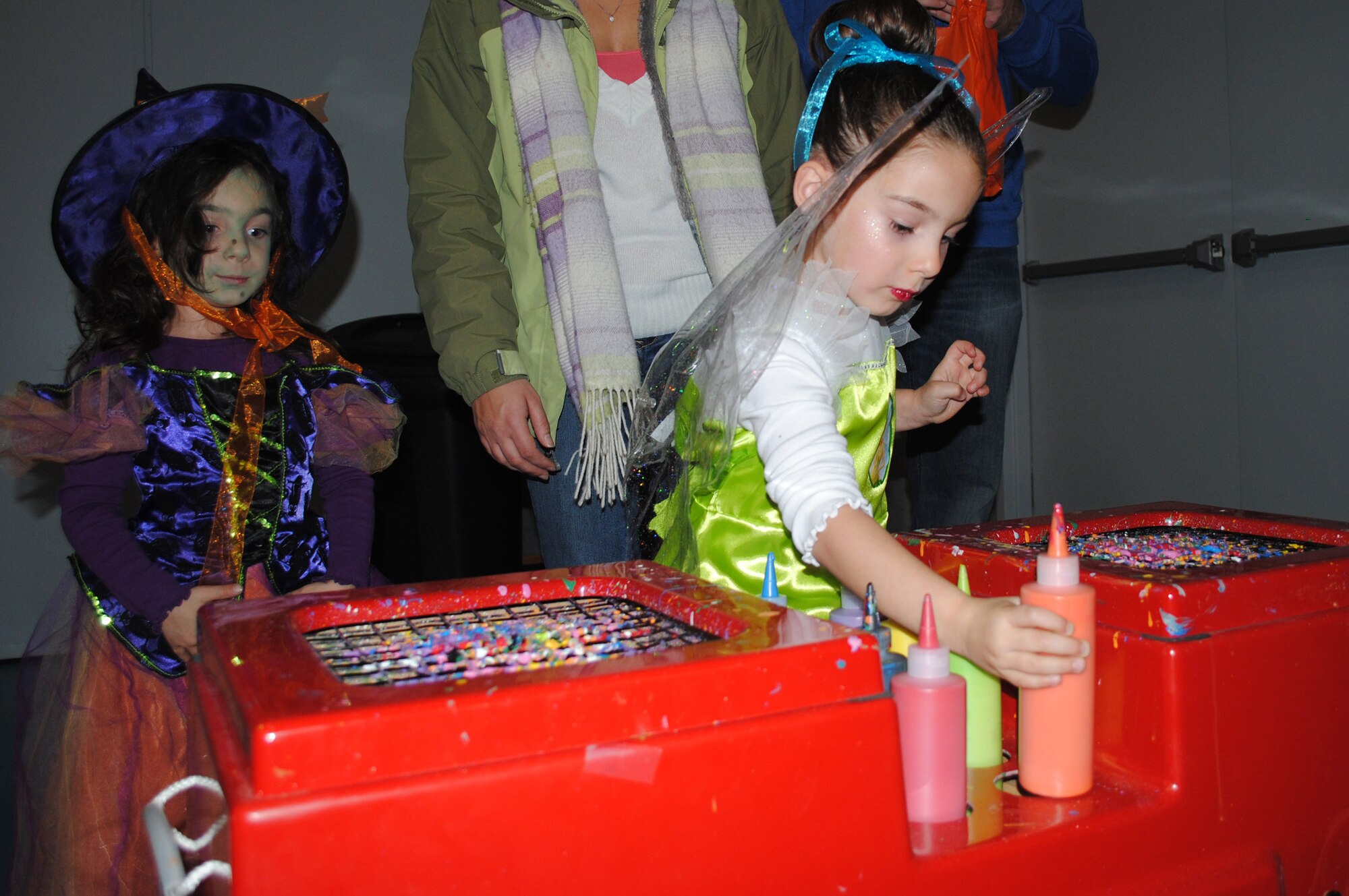 Elizabeth and Emily Nissen, 4, get creative at the spin-art station, one of many games available for youth during the Youth Center's annual Fall Festival, which took place Oct. 28. (U.S. Air Force photo/Airman 1st Class Katrina Heikkinen)