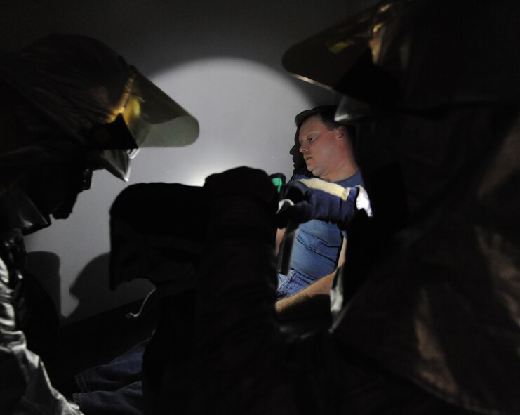 Fire-fighters from the 2nd Civil Engineer Squadron prepare to put a simulated tornado victim on a stretcher during a Major Accident Response Exercise on Barksdale Air Force Base, La., Nov. 1. The MARE was conducted to test the training and response time of emergency personnel after a devastating tornado. (U.S. Air Force photo/Airman 1st Class Micaiah Anthony)(RELEASED)