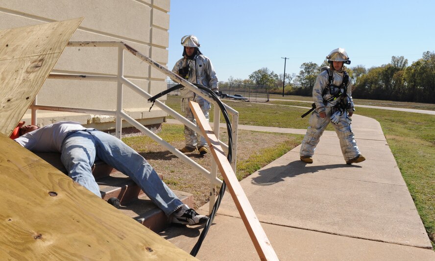 Fire-fighters from the 2nd Civil Engineer Squadron approach a simulated tornado victim surrounded by debris and electrical wire during a Major Accident Response Exercise on Barksdale Air Force Base, La., Nov. 1. The MARE was conducted to test the training and response time of emergency personnel after a devastating tornado. (U.S. Air Force photo/Airman 1st Class Micaiah Anthony)(RELEASED)