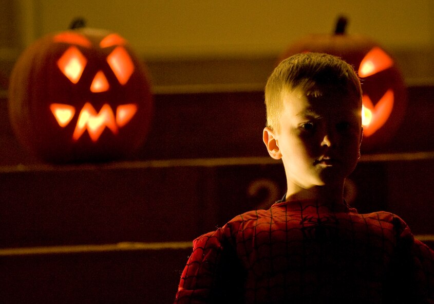 A costumed child sits on his porch offering candy to other passing children Halloween night on Barksdale Air Force Base, La. From 6 p.m. until 8 p.m. on Oct. 31, the base housing areas were open to Barksdale Airmen and their families for trick or treating. (U.S. Air Force photo/Senior Airman Chad Warren)(RELEASED)