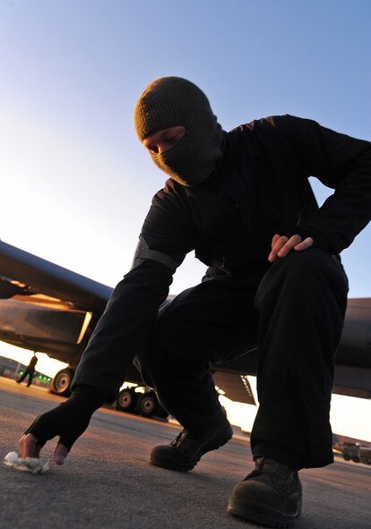 Senior Airman Dustin Bierwirth, 7th Equipment Maintenance Squadron, picks up debris while participating in a Foreign Object Debris walk Nov. 3, 2011, at Dyess Air Force Base, Texas. Examples of FOD are aircraft parts, rocks, broken pavement, ramp equipment, tools, bolts and vehicle parts. (U.S. Air Force photo by Airman 1st Class Peter Thompson/Released)