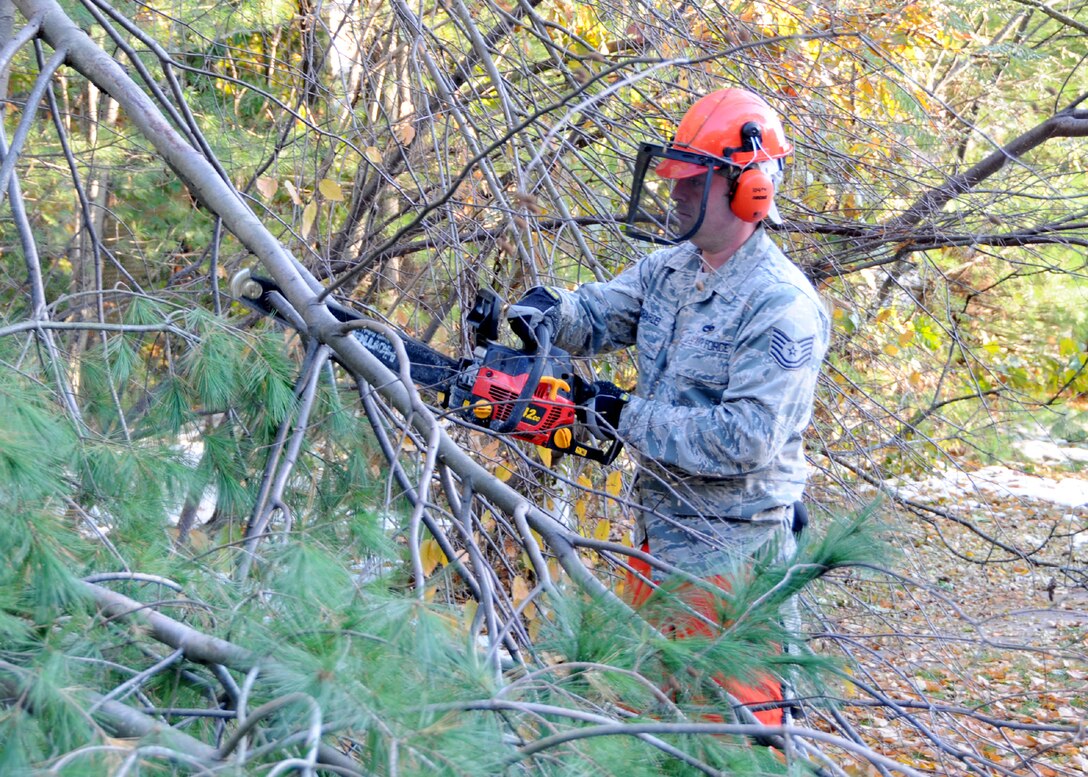 Technical Sgt. Aaron Richards from the 104th Fighter Wing, Westfield Mass., removes debris from a  road in Westfield,  Mass., on Tue, November 2, 2011 while working with the Hampden DPW .  He and more than 50 saw-teams were activated to support clean-up efforts in the state following the unusual snow storm that hit the eastern seaboard Oct 29-30th 2011. (photograph by Technical Sgt. Melanie J. Casineau)