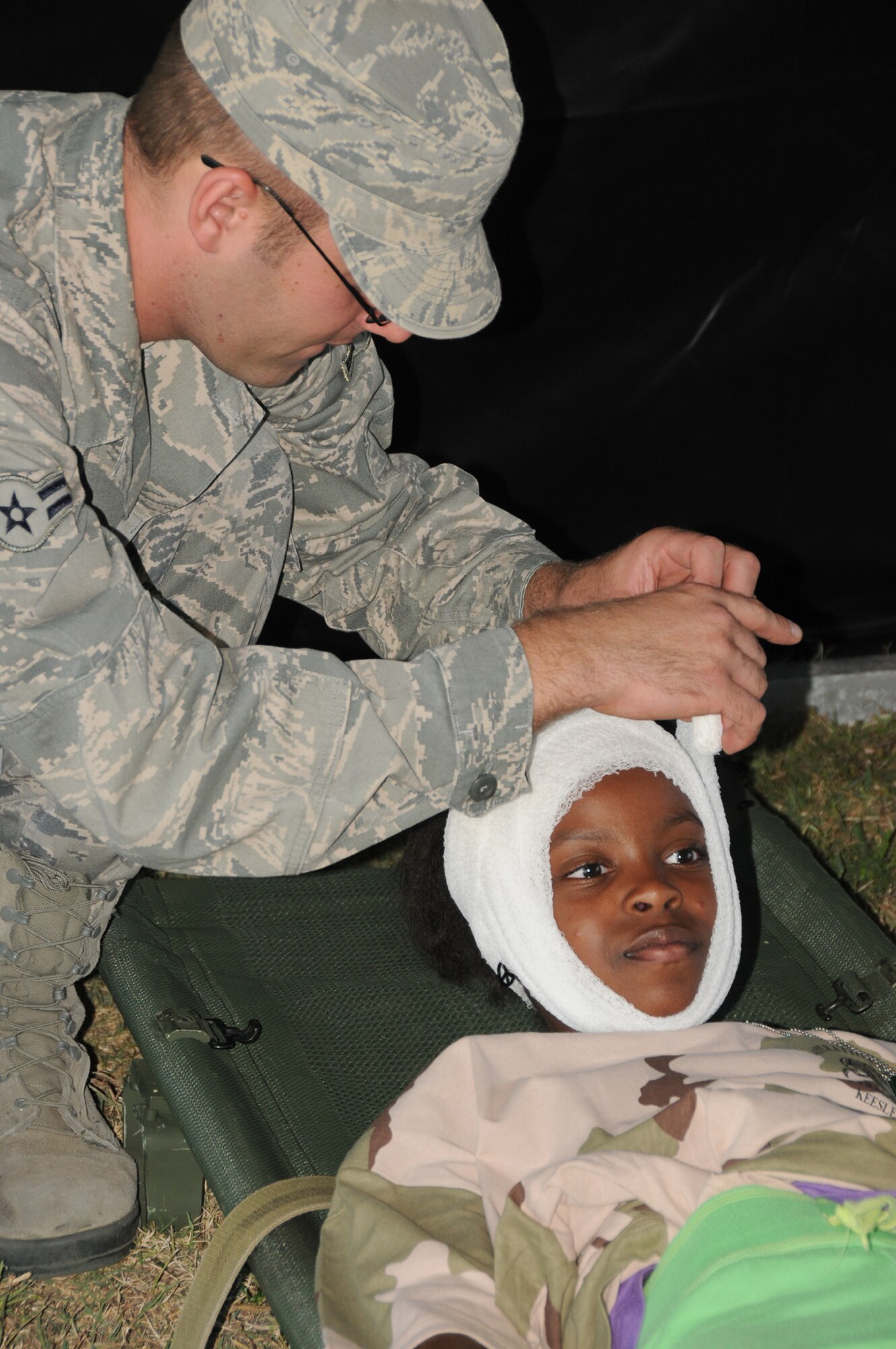 Airman 1st Class Donald Davenport, 81st Medical Operations Squadron, wraps the head of Tenay Malachi, 9, dependant of Master Sgt. Dina and Pedro Malachi, 336th Training Squadron, as a simulation to a head injury during Operation Hero, Oct. 15, 2011, Keesler Air Force Base, Miss.  Operation Hero is presented twice a year to give parents a chance to expose their children to what happens when they leave home for deployment tasking or temporary duty.   (U.S. Air Force photo by Kemberly Groue)