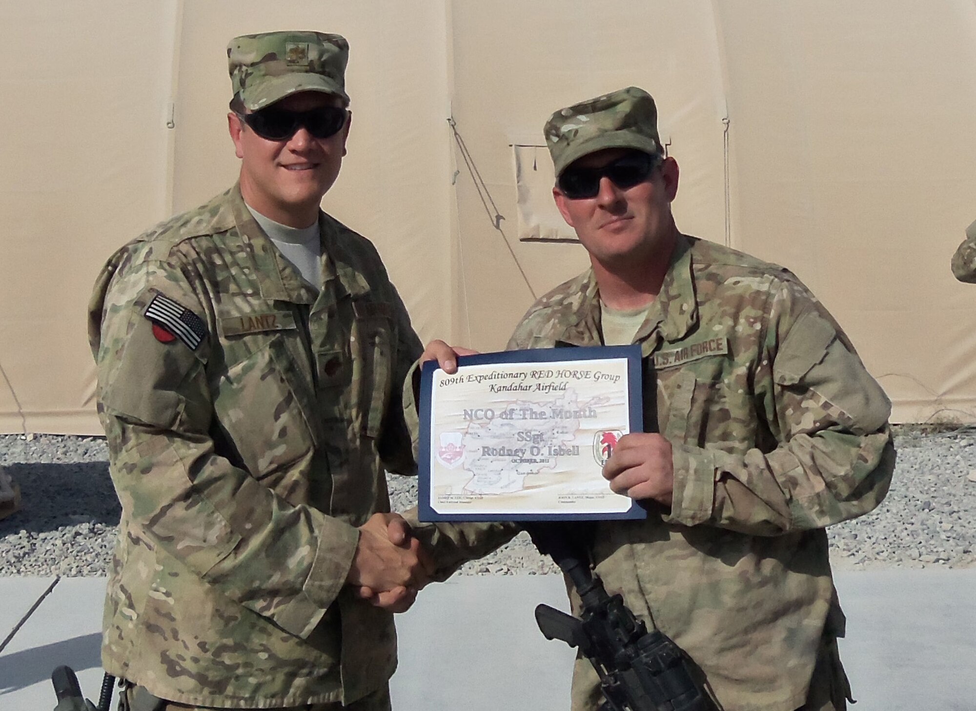 Staff Sgt. Rodney Isbell (right), 567th RED HORSE, receives the NCO of the Month award from the commander of the 809th Expeditionary RED HORSE. (USAF photo courtesy of 567RHS)