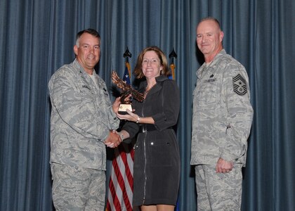 Col. Richard Murphy, 12th Flying Training Wing Commander, and Chief Master Sgt. Steven Jones, 12th FTW command chief, presents Rhonda Chavez, 902nd Contracting Squadron, Civilian Non-Supervisor of the Quarter category III award during the Joint Base San Antonio Randolph 3rd Quarter Award Ceremony at the base theater at Randolph Air Force Base, Texas, Nov. 2.(U.S. Air Force photo/Melissa Peterson)