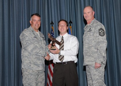 Col. Richard Murphy, 12th Flying Training Wing Commander, and Chief Master Sgt. Steven Jones, 12th FTW command chief, presents Joseph Domeier with the Civilian Non-Supervisor of the Quarter Category II award during the Joint Base San Antonio Randolph 3rd Quarter Award Ceremony at the base theater at Randolph Air Force Base, Texas, Nov. 2.(U.S. Air Force photo/Melissa Peterson)