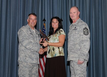 Col. Richard Murphy, 12th Flying Training Wing Commander, and Chief Master Sgt. Steven Jones, 12th FTW command chief, presents Margie Castle, 558th Flying Training Squadron, with the Civilian Non-Supervisor of the Quarter award during the Joint Base San Antonio Randolph 3rd Quarter Award Ceremony at the base theater at Randolph Air Force Base, Texas, Nov. 2.(U.S. Air Force photo/Melissa Peterson)