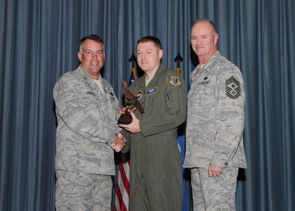 Col. Richard Murphy, 12th Flying Training Wing Commander, and Chief Master Sgt. Steven Jones, 12th FTW command chief, presents Tech. Sgt. Shawn Compton, 558th Flying Training Squadron Basic Sensor Operating Course instructor supervisor, with the Non-Commissioned Officer of the Quarter award during the Joint Base San Antonio Randolph 3rd Quarter Award Ceremony at the base theater at Randolph Air Force Base, Texas, Nov. 2.(U.S. Air Force photo/Melissa Peterson)