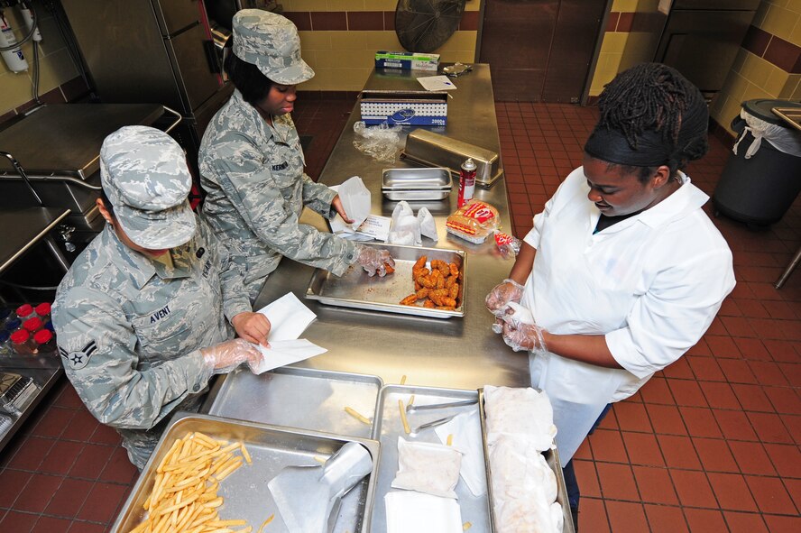 Airman 1st Class Precious Avent, Airman Marie Kernizan and Rose Artis prepare bags of food for lunch at the Expanded Flight Kitchen on Seymour Johnson Air Force Base, N.C., Nov. 1, 2011. The Expanded Flight Kitchen's main customers are flightline personnel from the 4th Aircraft Maintenance Squadron, 916th Air Refueling Wing, Wing Safety, 4th Operations Support Squadron and Junior Reserve Officer Training Corps cadets. Avent is a native of Henderson, N.C., Kernizan is from West Orange, N.J., and Artis hails from Goldsboro, N.C. All are part of the 4th Force Support Squadron Expanded Flight Kitchen crew. (U.S. Air Force photo by Senior Airman Rae Perry)