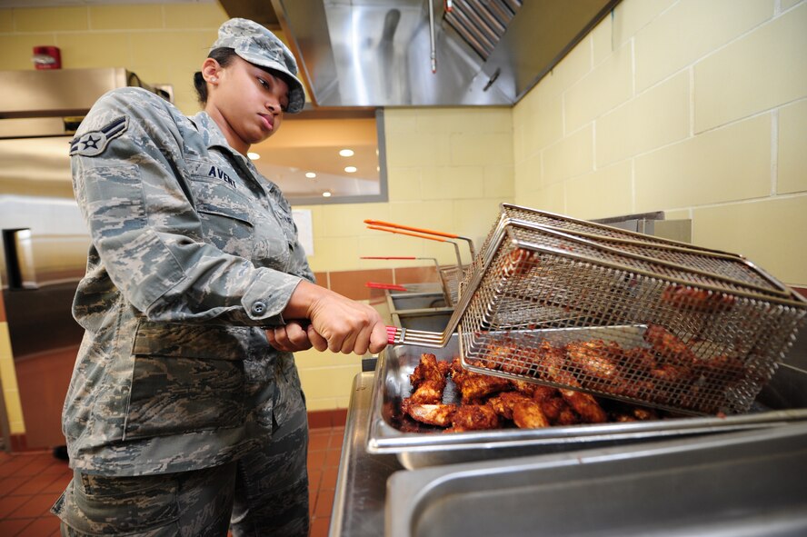 Airman 1st Class Precious Avent, 4th Force Support Squadron food services journeyman, removes chicken wings from a deep fryer basket in preparation for the lunch rush at the Expanded Flight Kitchen on Seymour Johnson Air Force Base, N.C., Nov. 1, 2011.The Flight Kitchen handles more than 100 customers during a typical lunch period. Avent is a native of Henderson, N.C. (U.S. Air Force photo by Senior Airman Rae Perry)
